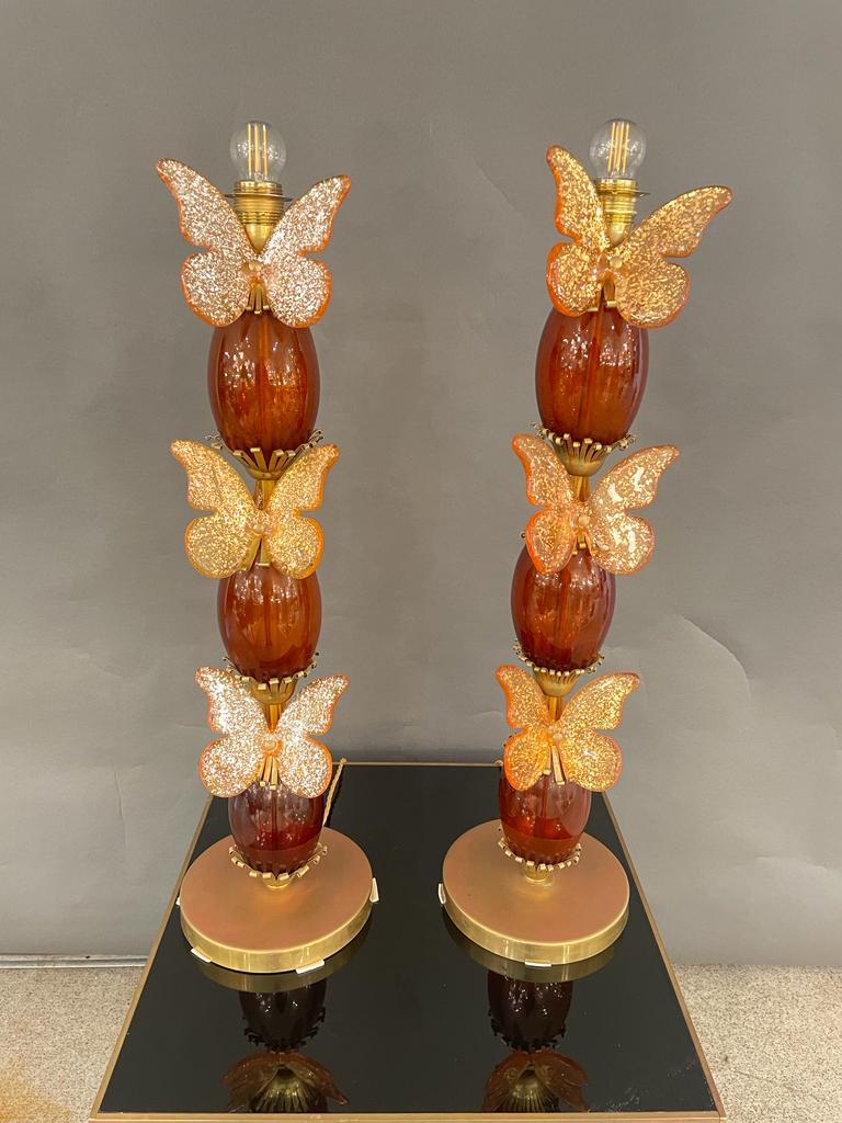 Une fantastique paire de lampes de table italiennes en verre de Murano ambré, ornées de papillons dorés et de décorations en laiton. Circa 1970.