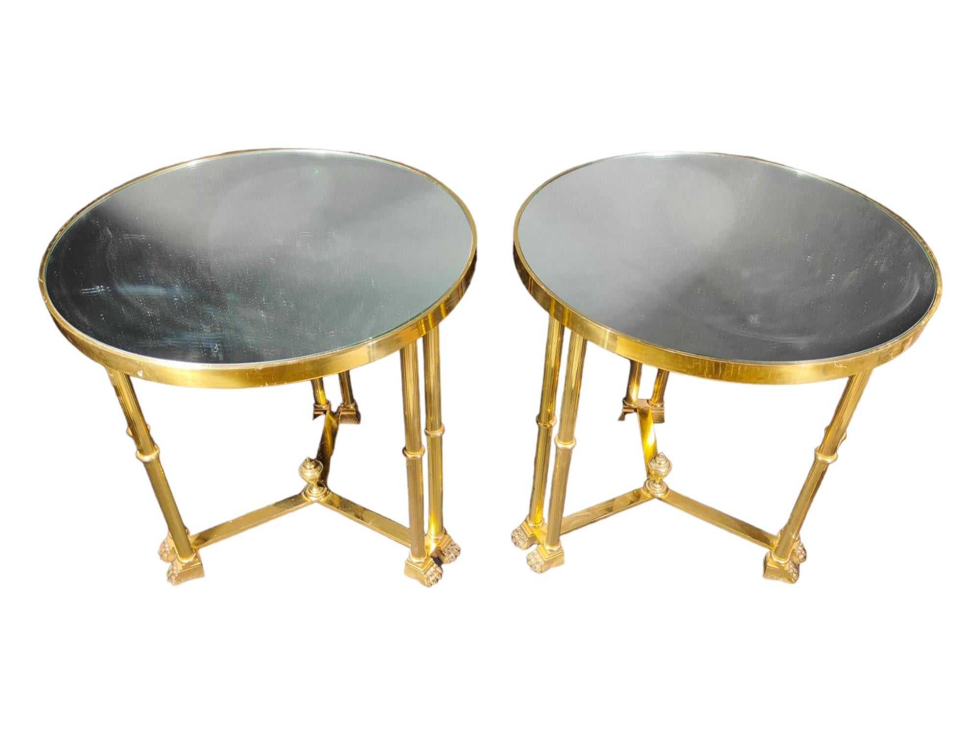 Elegant pair of 1950s Italian empire style tables in golden brass and glass. Measurements: 61 cm in diameter and 60 cm in height.