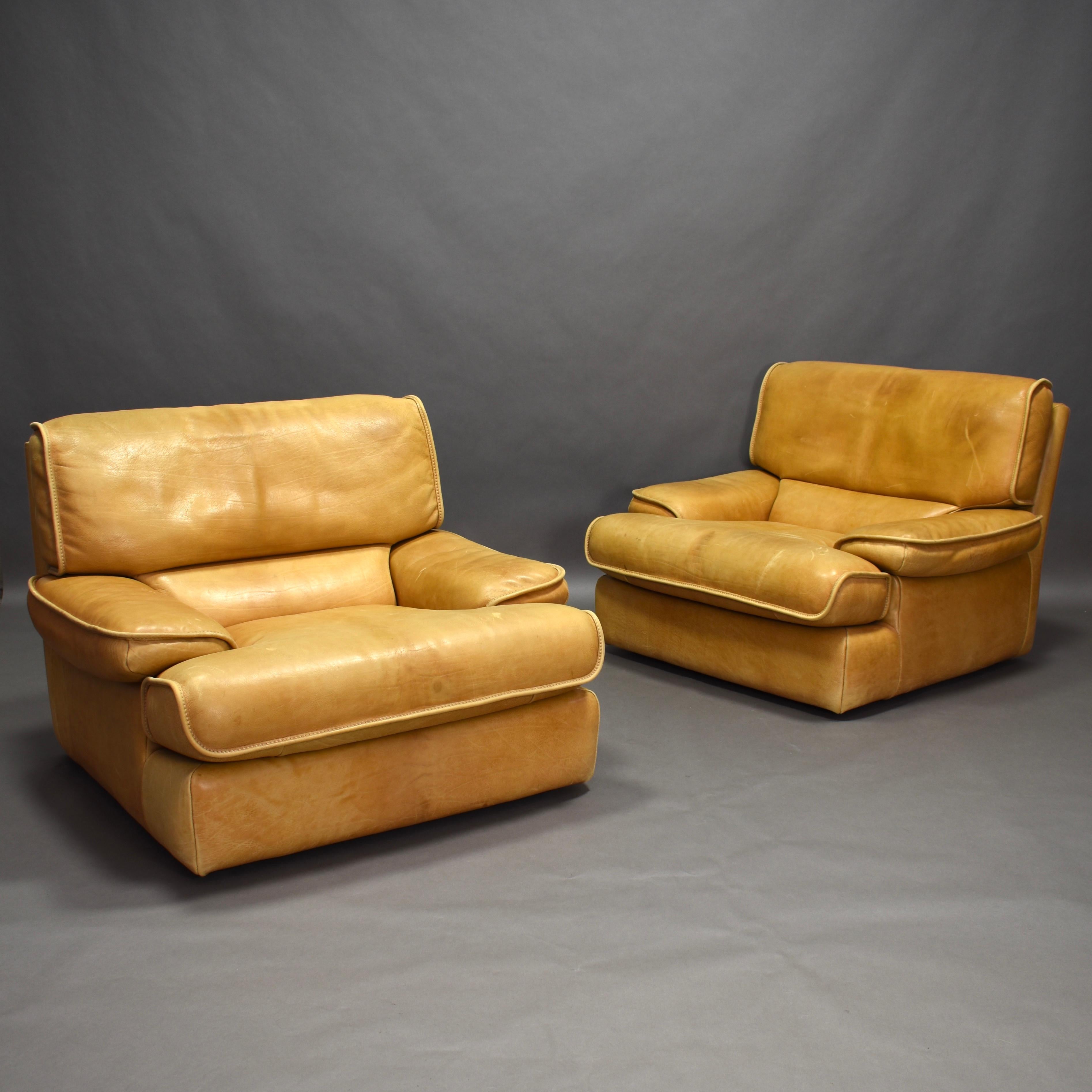 Pair of 1970s club armchairs. The chairs are made in a thick and sturdy tan leather in high quality. They are very comfortable, durable and still remain in very good vintage condition. Some normal signs of age and use but with minimal wear and no