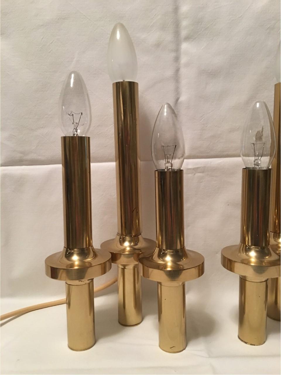 A pair of Italian table lamps made of brass with three lights. In the style of Gaetano Sciolari from the 1970s. Each fixture requires three European E14 candelabra bulbs, each bulb up to 40 watts. In good working condition. Equipped with original