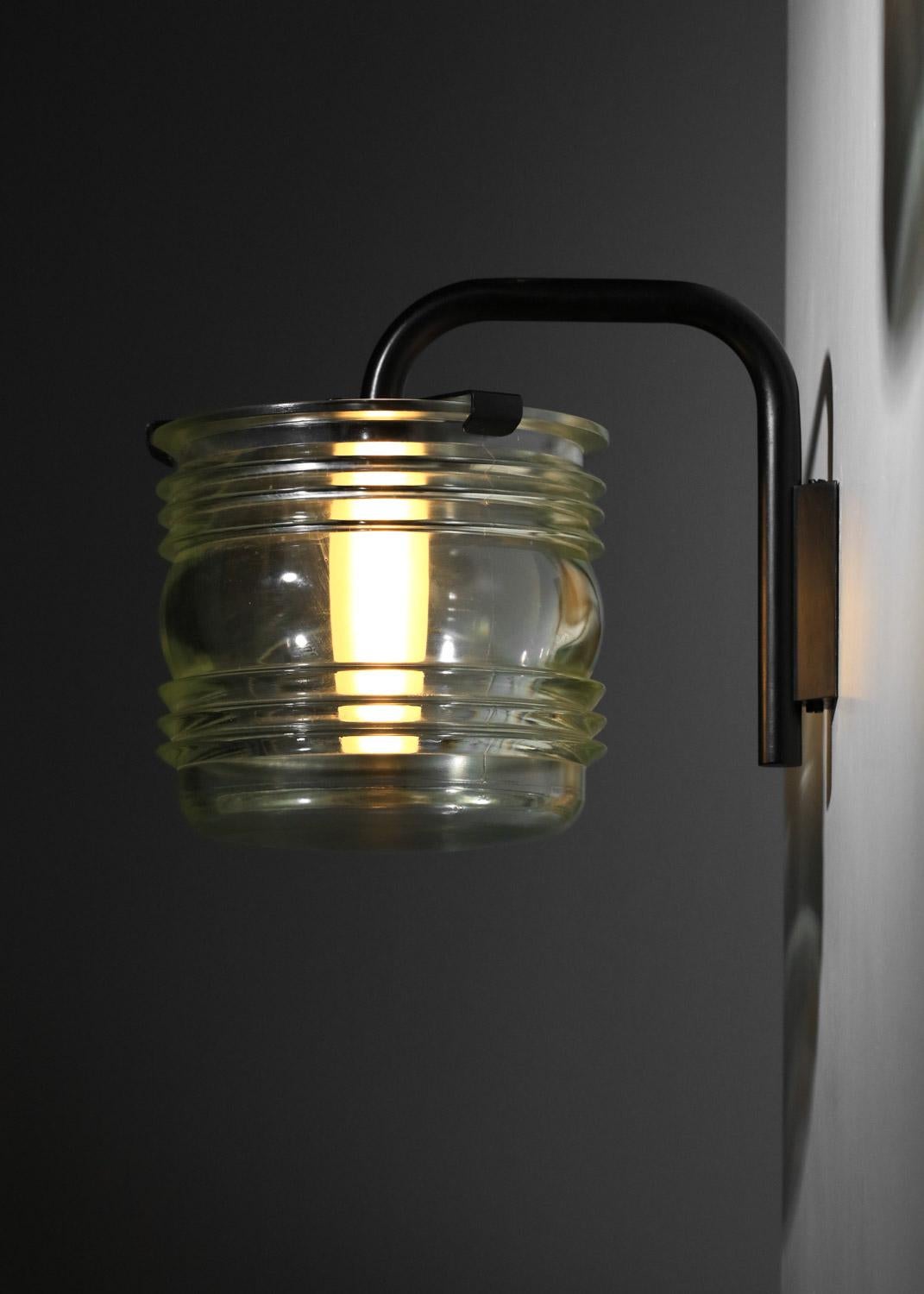 Pair of wall lights from the 1960s by Italian designer Tito Agnolli. Solid brass structure lacquered in black (original paint) and thick transparent glass shade in lantern style. Understated and very elegant design. In good vintage condition, with