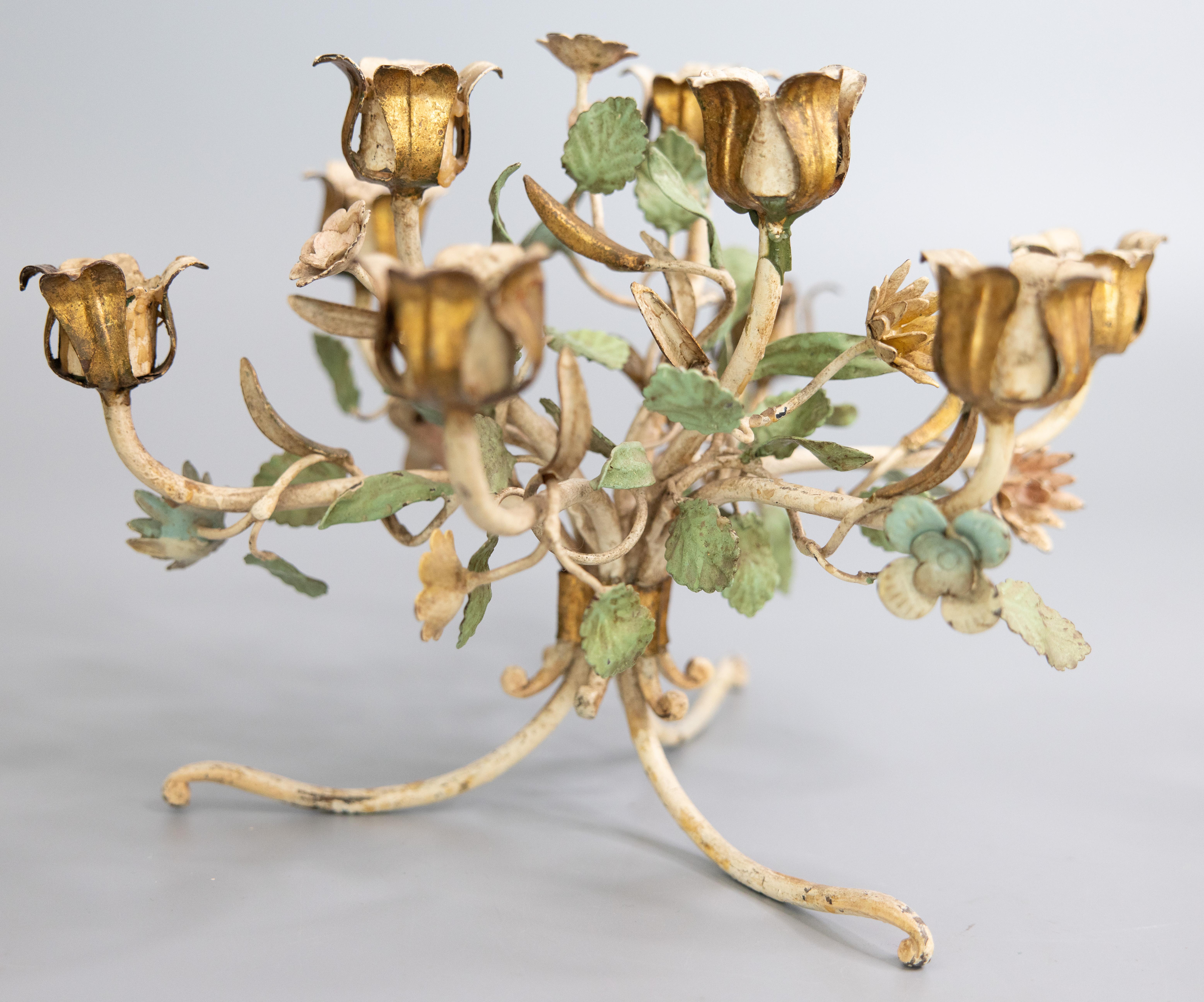 A lovely pair of Mid-Century Italian gilded and hand painted tole and wrought iron nine arm floral candelabras or table centerpieces, circa 1950. These beautiful candle holders are decorated with gilt accents, lovely pastel wildflowers, and