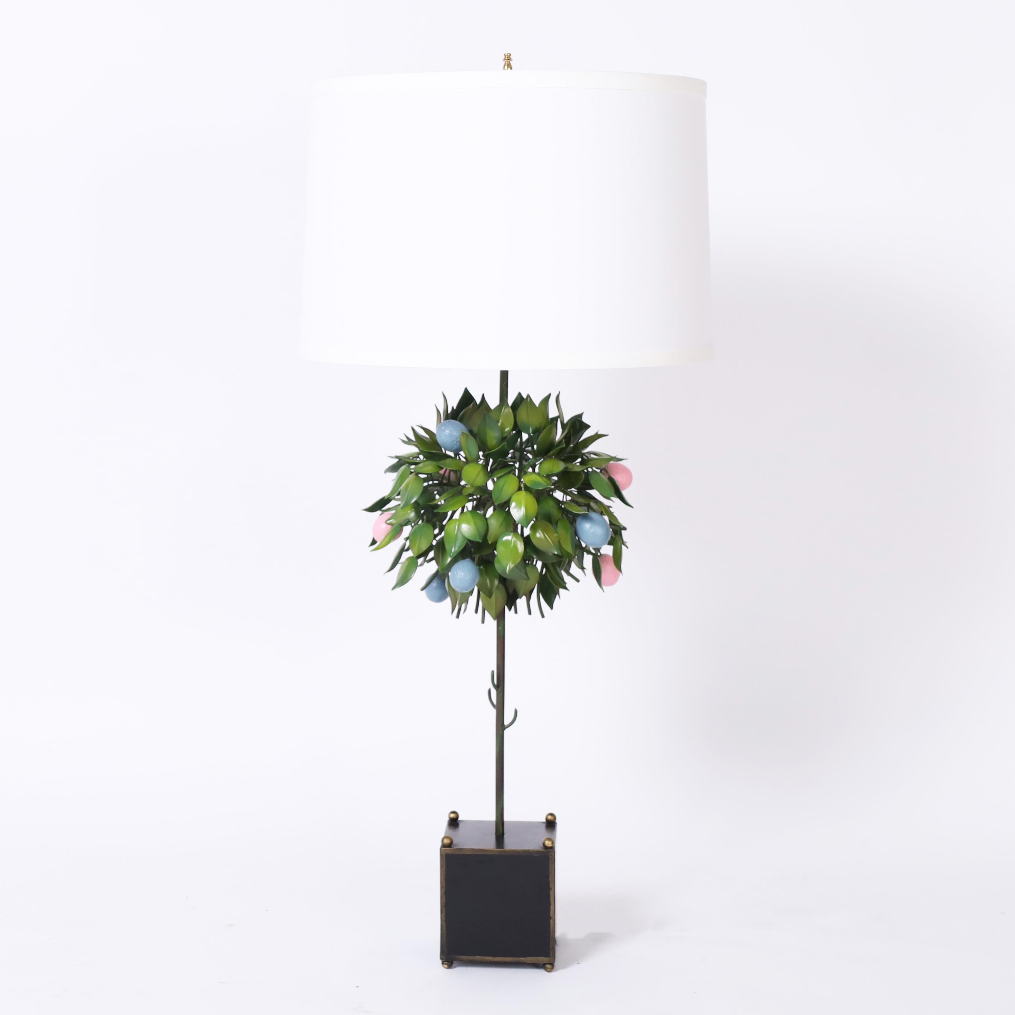 Amusing yet chic pair of mid century tole table lamps handcrafted in metal in a lemon tree form with blue and pink fruit in a neoclassic planter with brass finials and feet.