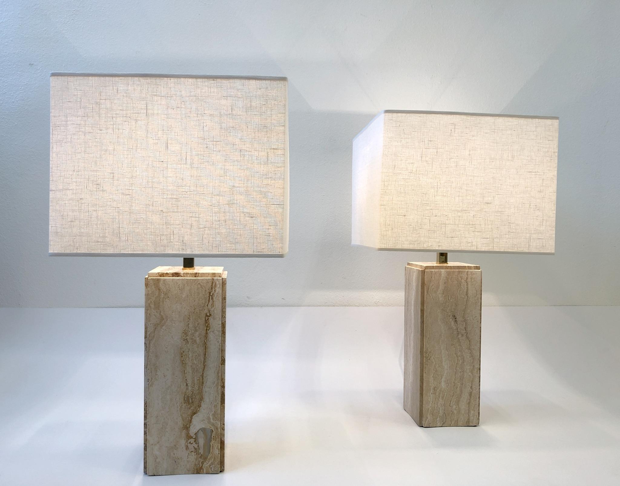 A spectacular pair of Italian travertine and polish brass table lamps design in the 1970s by Raymor.  The lamps have been newly rewired with all new brass hardware and new vanilla linen shade. The lamps are marked made in Italy.
Overall dimension: