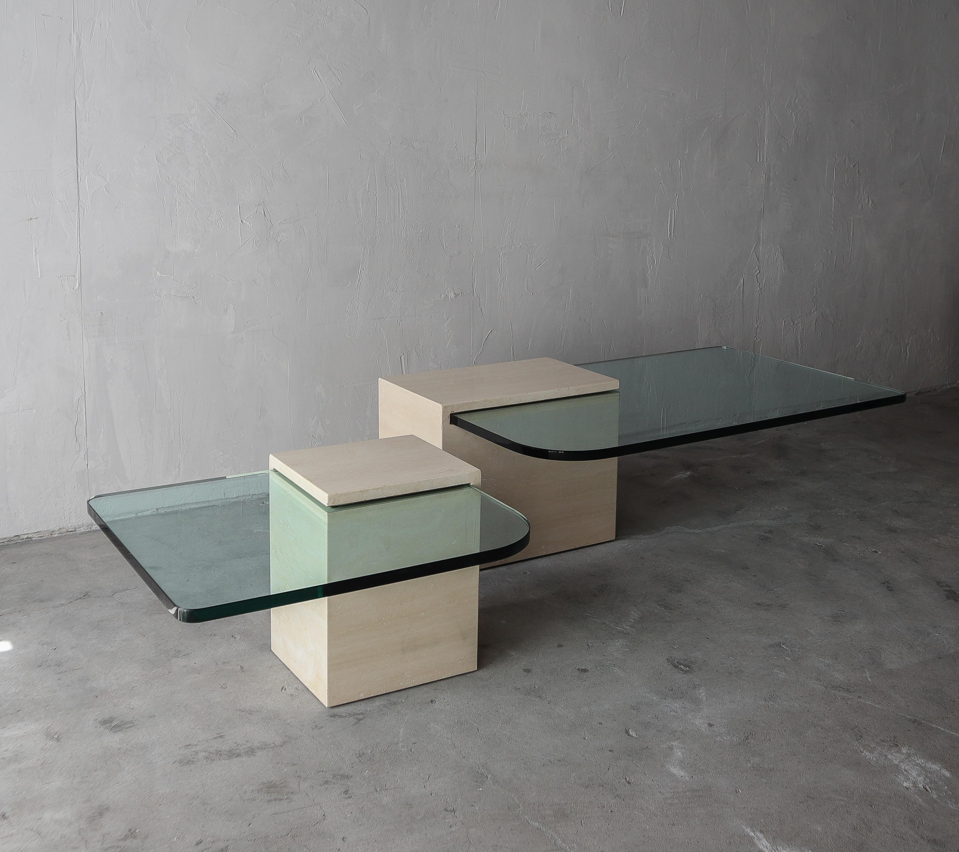 A gorgeous pair of travertine and glass coffee tables. A highly versatile duo which can be arranged in a multitude of configurations. They can be used together as a bunching coffee table, or separately as a coffee table and side table. These tables