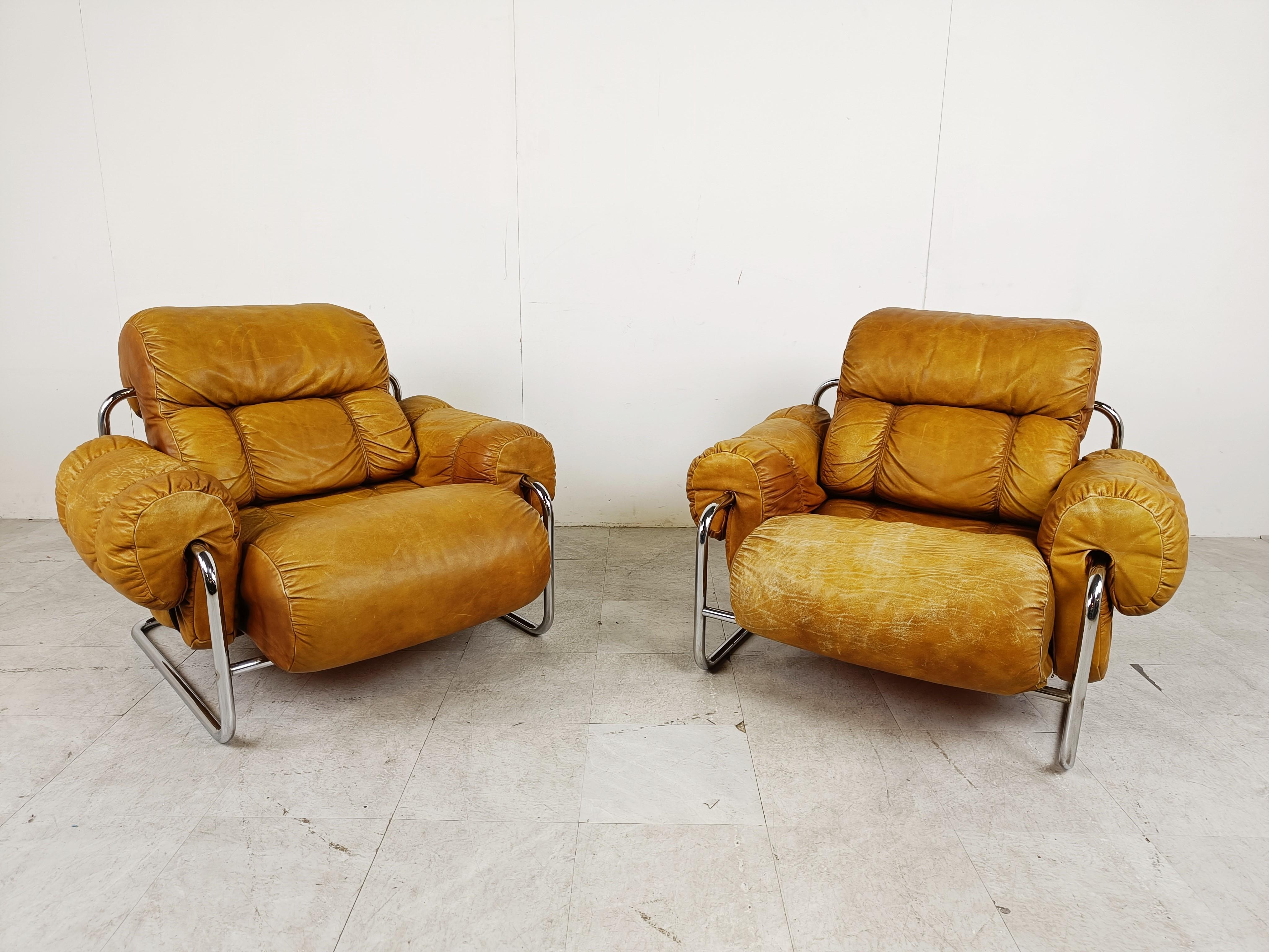 Pair of mid century Tucroma armchairs designed by Guido Faleschini for Mariani.

The armchairs consists of a chromed tubular frame with thick and nicely patinated leather cushions strapped to it.

Striking mid century italian design which are