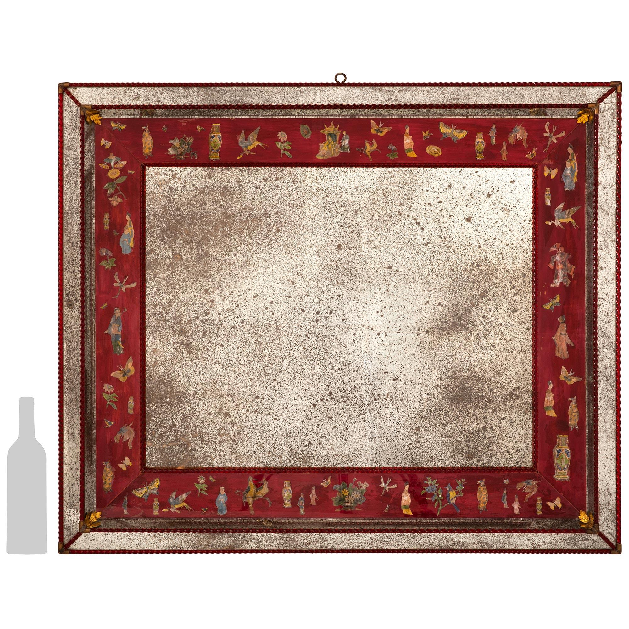 A stunning and unique pair of Italian turn of the century Églomisé and Lacca Povera mirrors. These beautiful rectangular mirrors are decorated by several red twisted glass bands throughout. Bordering the central mirror plate are highly detailed red