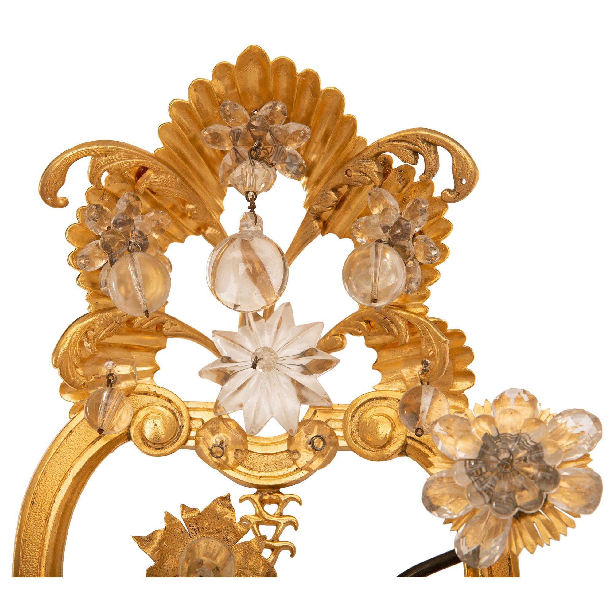 Patinated Pair of Italian Turn of the Century Louis XVI St. Ormolu and Crystal Sconces For Sale
