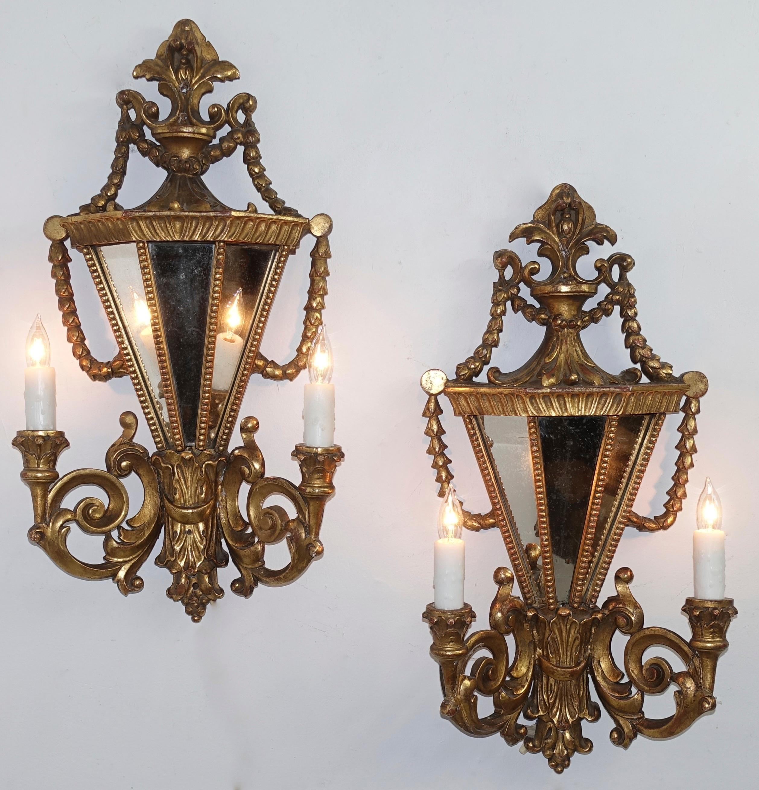 A pair of Italian two-arm and light giltwood and mirror wall sconces in the Baroque style,

early 20th century, Italy.