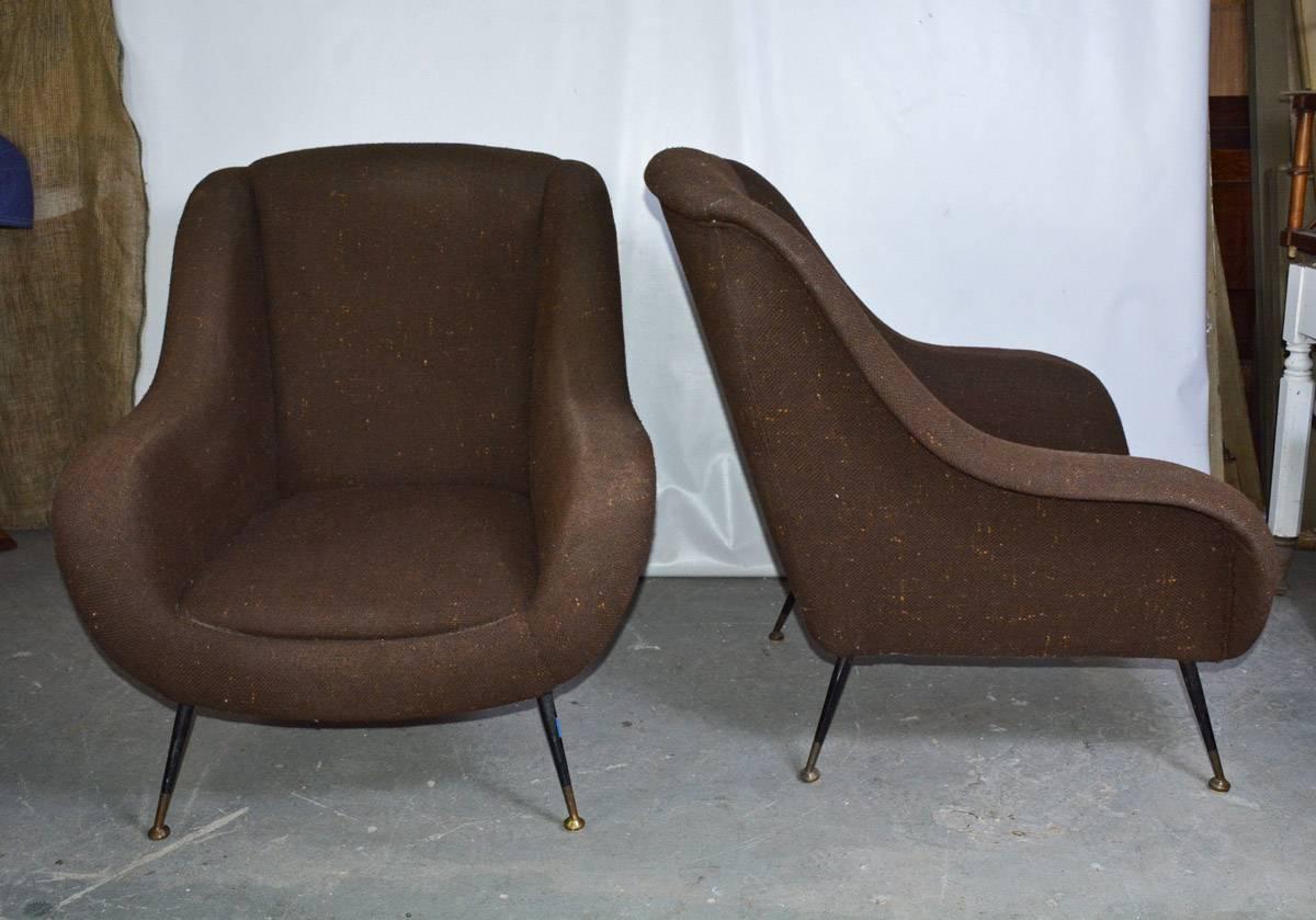 A good pair of mid-century modern Italian upholstered lounge chairs the chairs have narrow splayed legs in black enameled metal with brass fittings. Great looking from all angles. Versatile design perfectly suited for living room, bedroom, or as