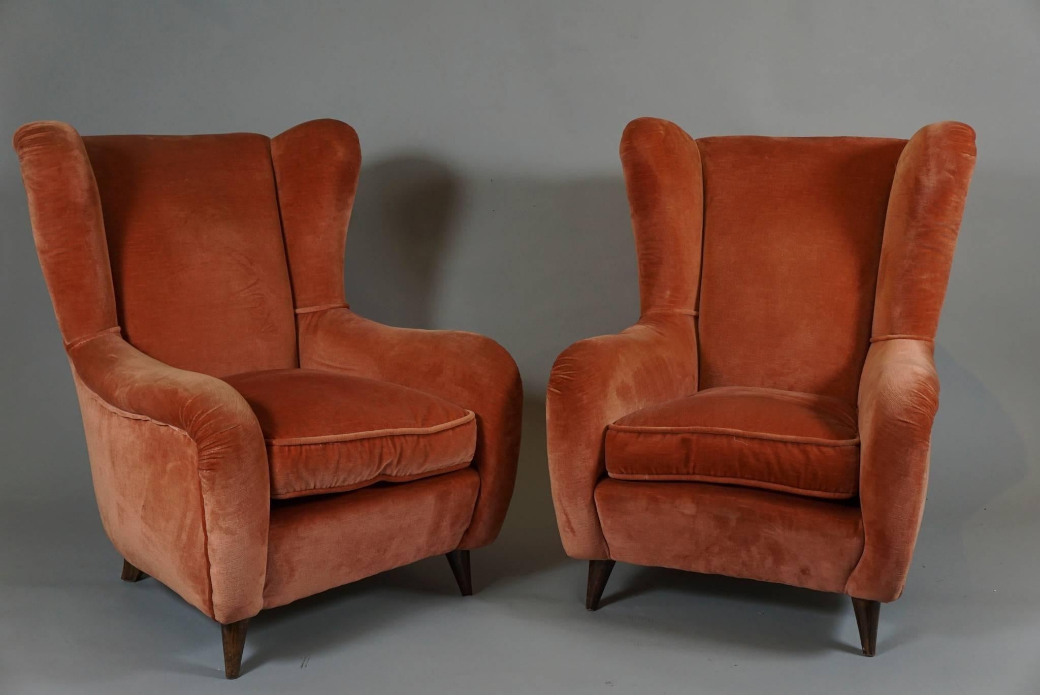 Italian circa 1950 club chairs with rolled arms and shaped wings
deep pink velvet upholstery.