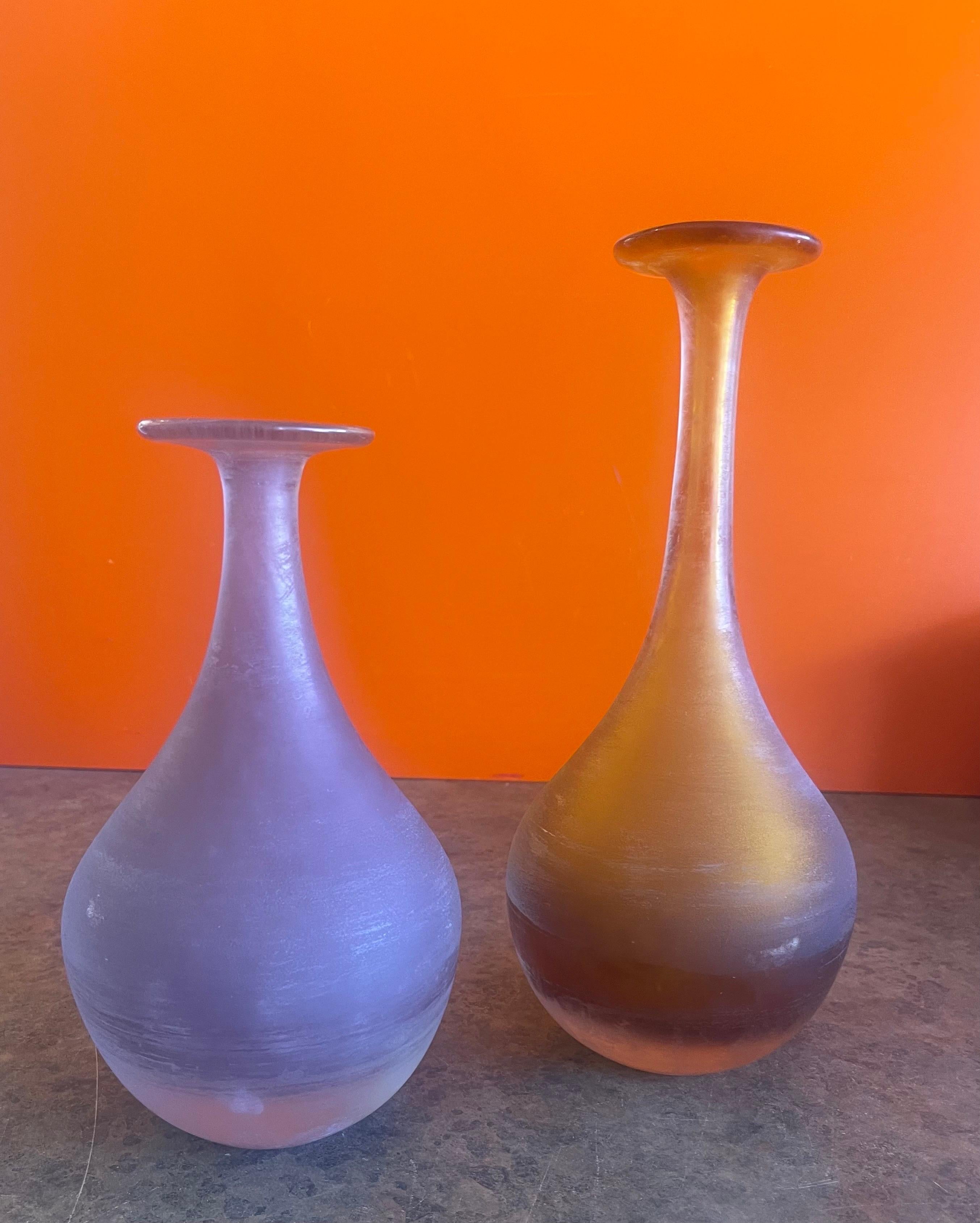Gorgeous pair of post-modern Italian Venetian art glass vases, circa 1990s. The smaller vase is a bluish purple in color and the taller one is a striking yellow. The pair are in very good vintage condition with no chips or cracks and measure 5.5