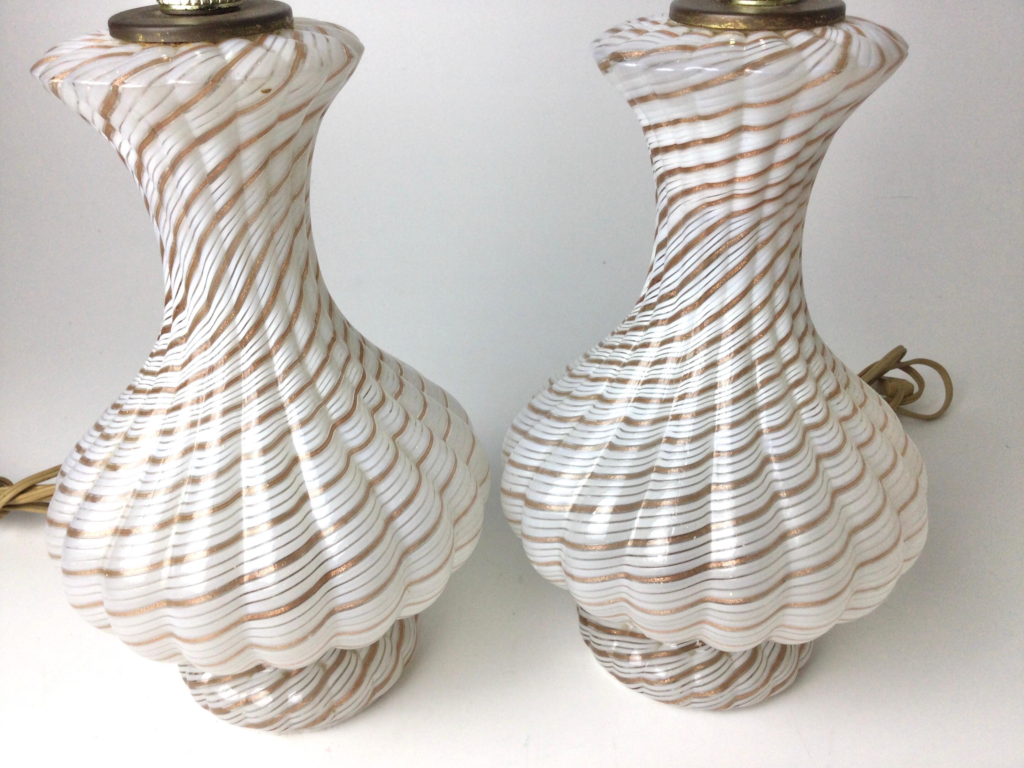 Nice pair of small bedroom lamps. Each 12 1/2” tall to the top of the sockets. 5 1/2” in diameter at the widest point. The glass has ribbons of white and gold running through. Wording is good. New felt on bottoms.