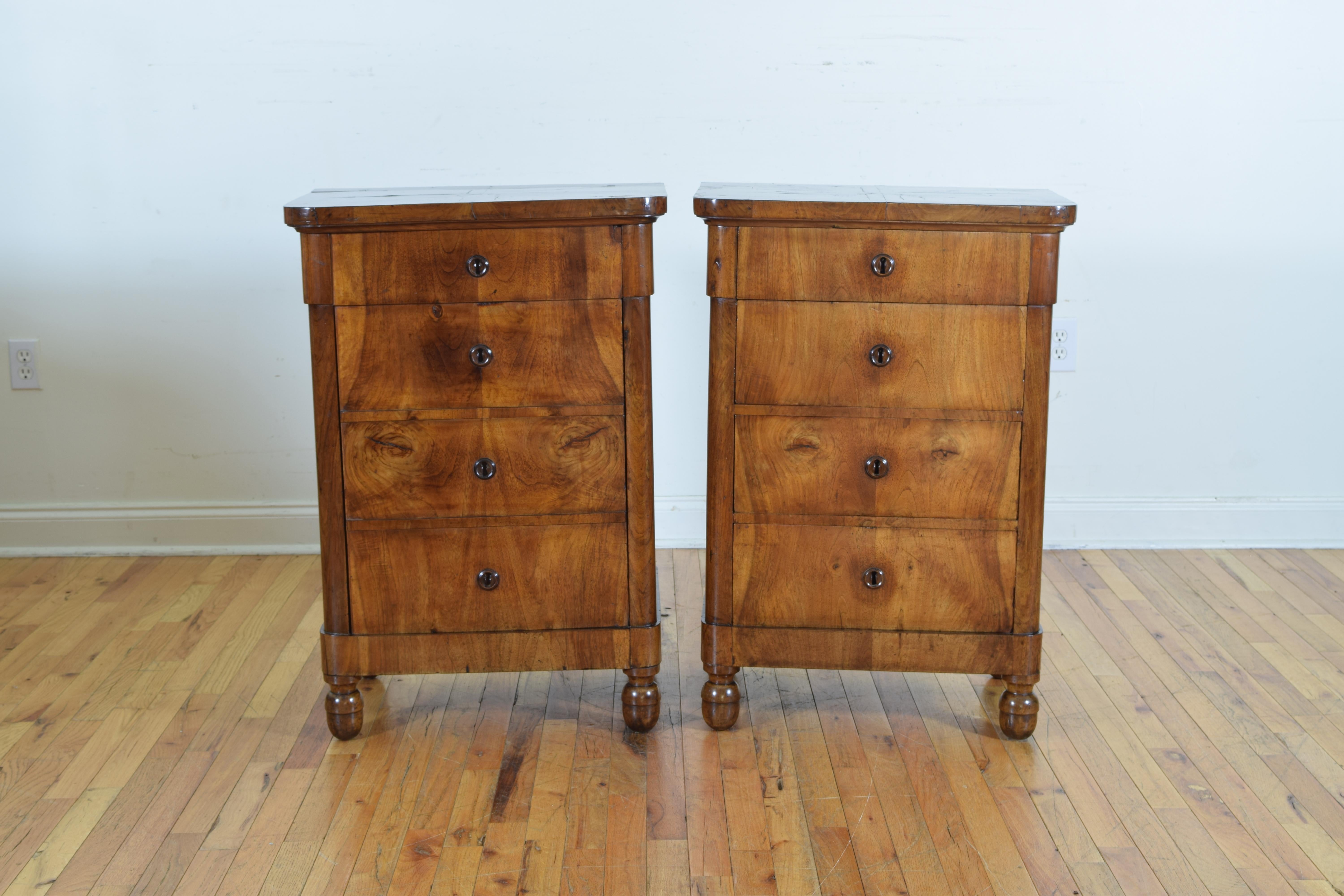 covered entirely in matched grain walnut veneers with solid walnut feet, having rectangular top with rounded front corners above conforming cases, one commode having four drawers the other with a hinged top and hinged door, acorn shaped feet