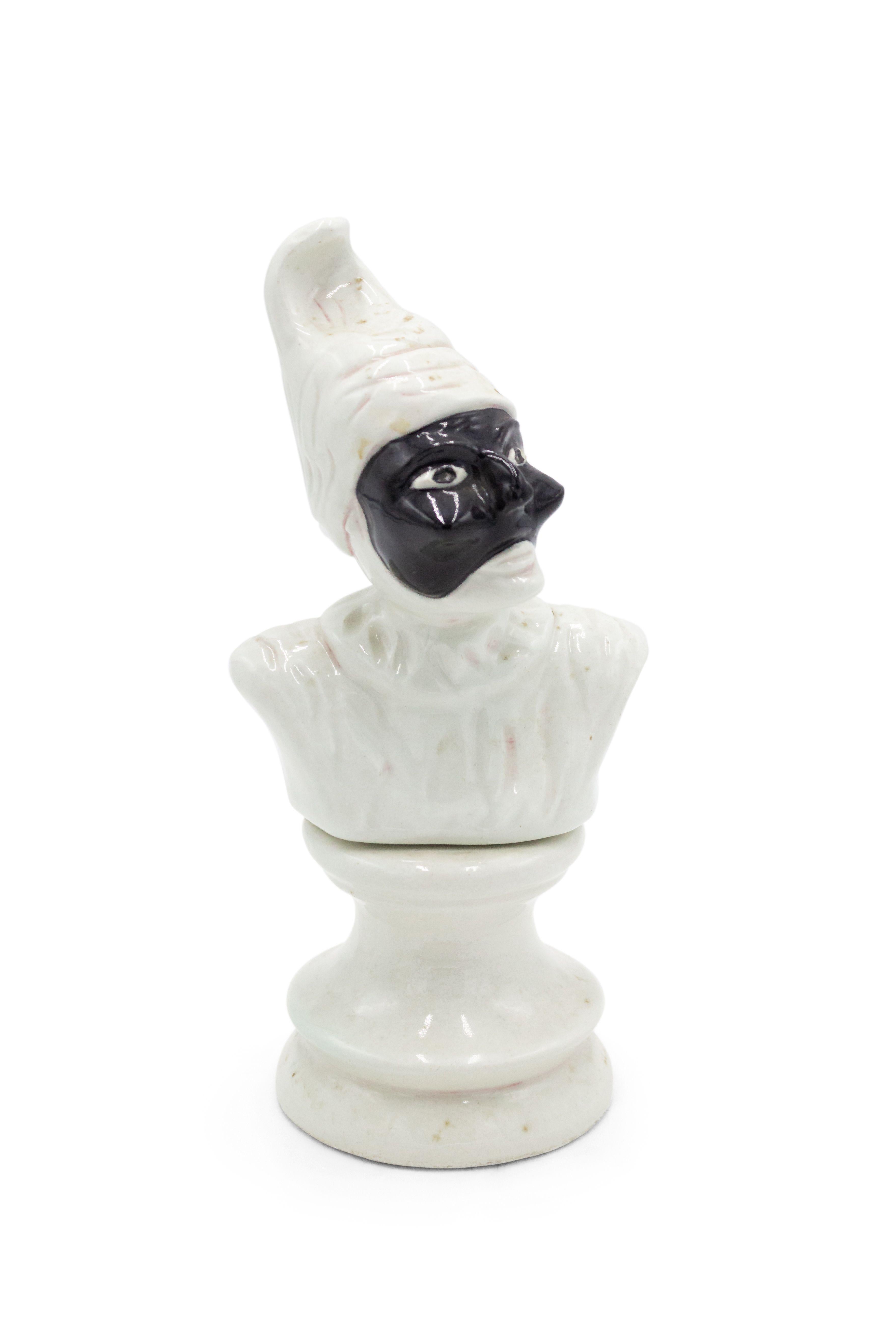 Pair of Italian Venetian style (20th Cent) porcelain busts of clowns wearing a black mask resting on a low pedestal.
  