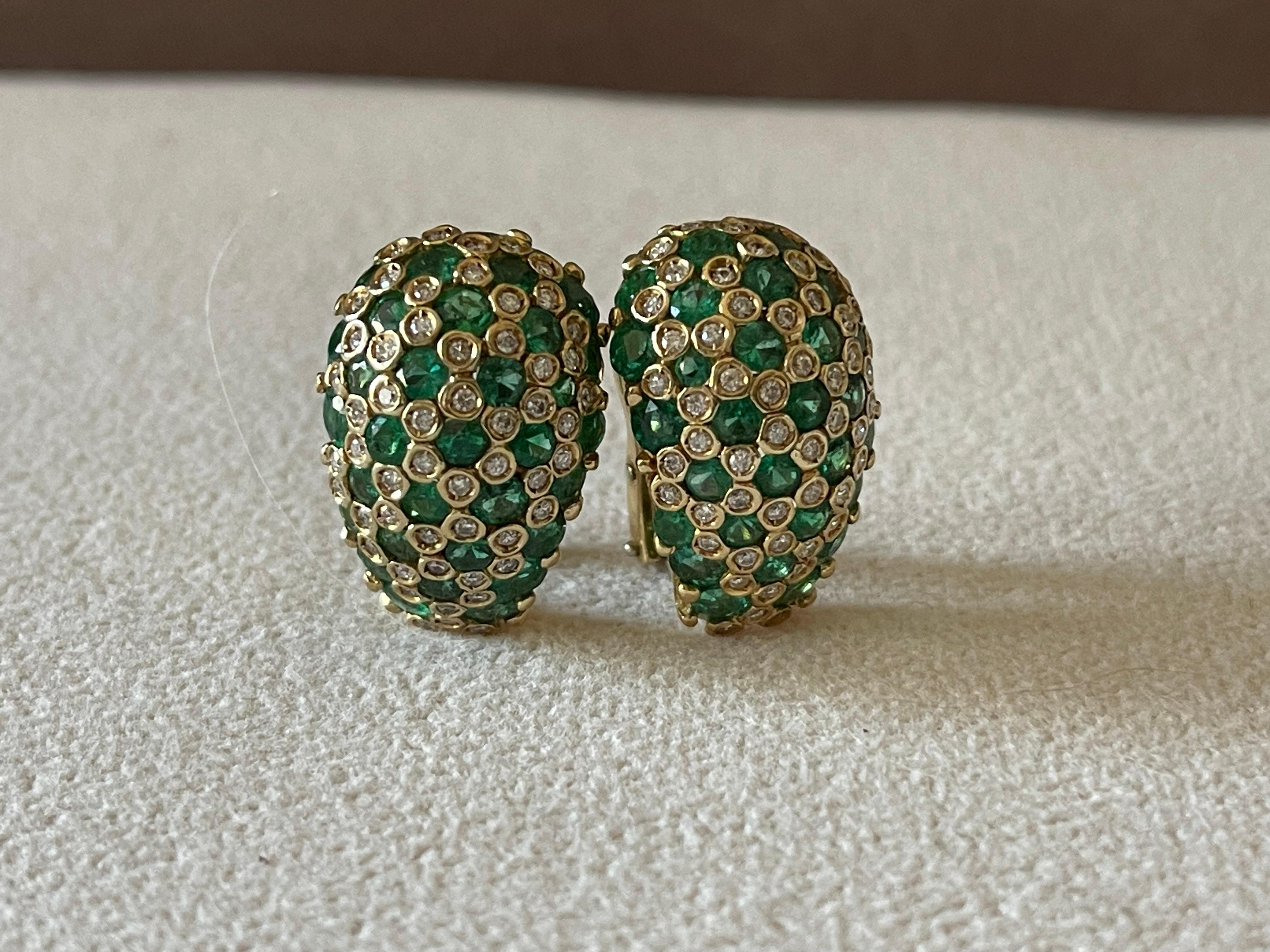 A timeless pair of Vintage earrings in 18 K yellow Gold featuring 64 vivid green round Emeralds weiging ca. 5.50 ct  and brilliant cut Diamonds. Made in 18 K yellow Gold with italian marks. 
The Omega-back style caters for pierced ears only. These