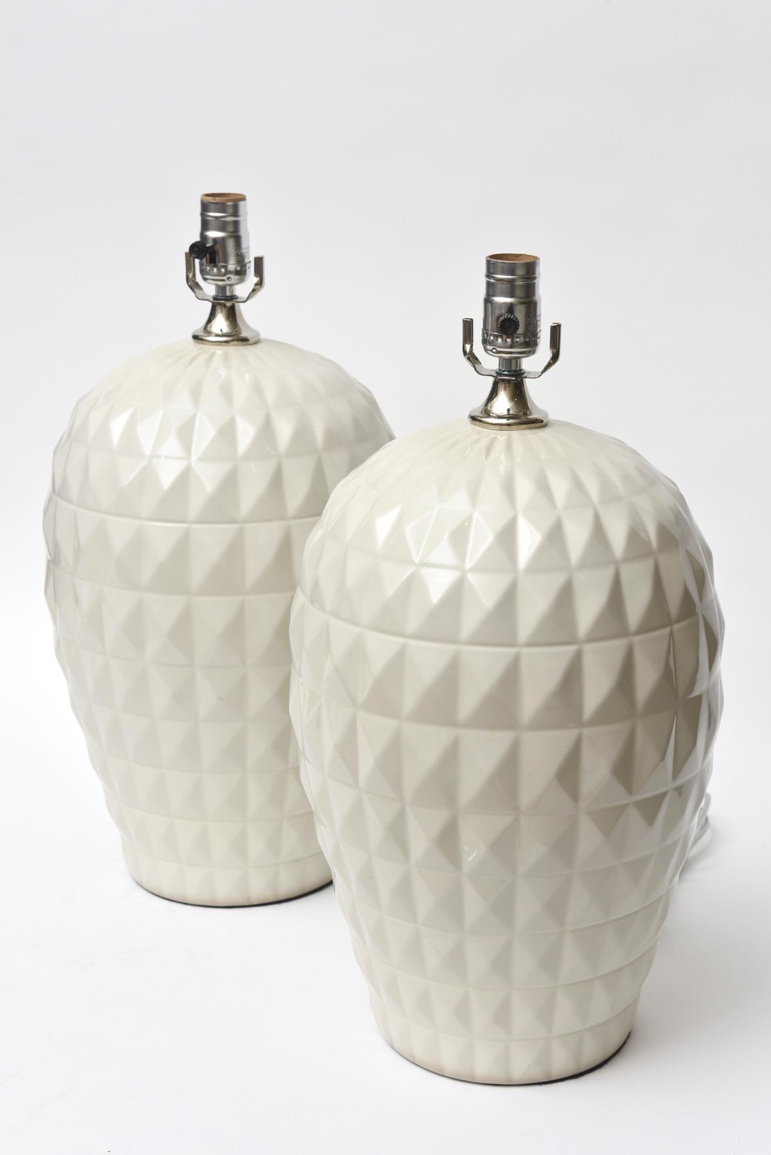These amazing pair of vintage Italian 1960s ceramic lamps are textural glazed forms of geometric diamond shaped forms. They are dimensional. They are off-white glazed and have been newly rewired and cleaned. They do not have shades nor harps. The
