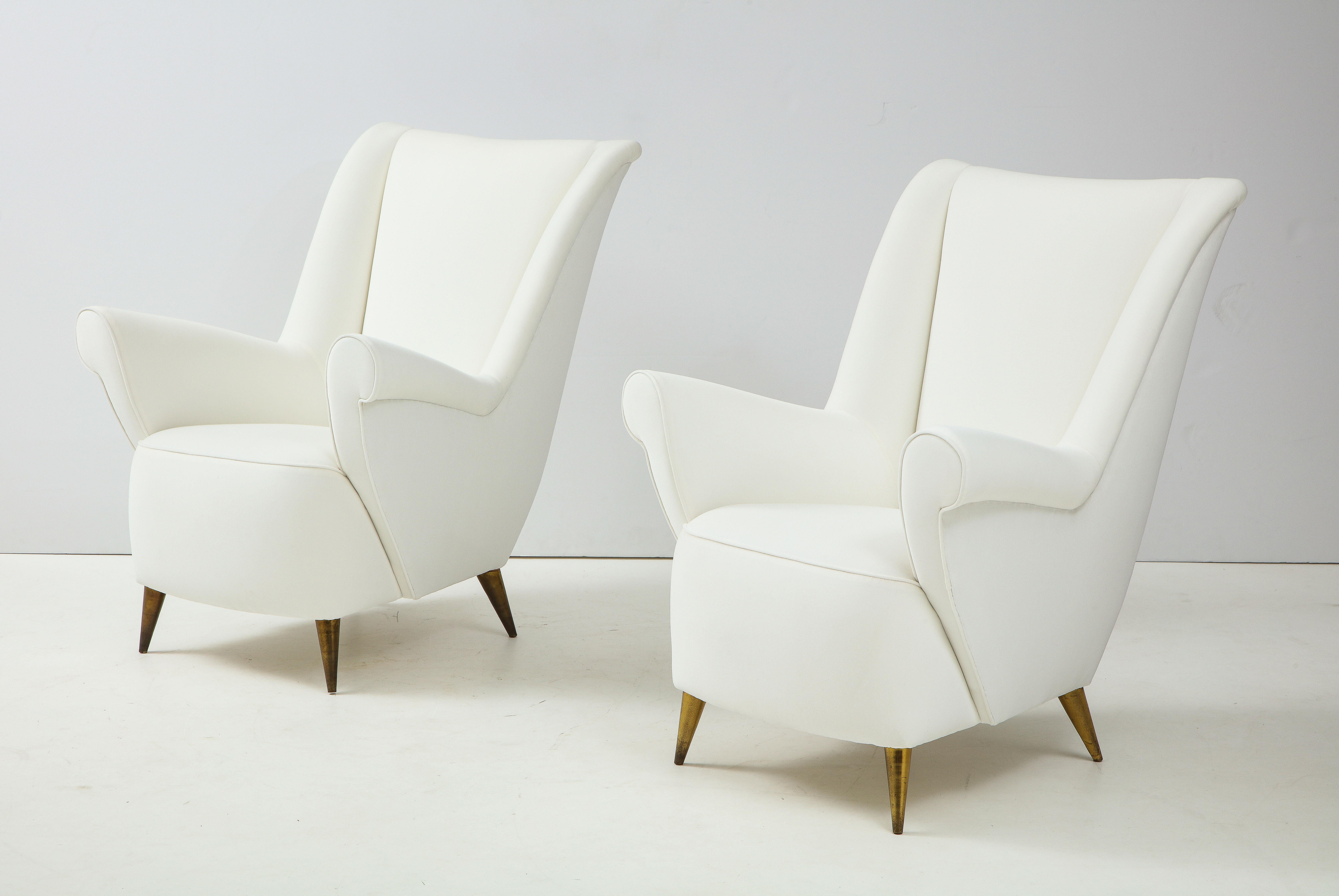 A stunning pair of Italian vintage lounge or high back chairs designed by Gio Ponti in 1955 for Editions ISA, Bergamo. These elegant chairs feature high backs, a sculpted profile, and refined, sensuous lines designed for deep comfort. The seats are