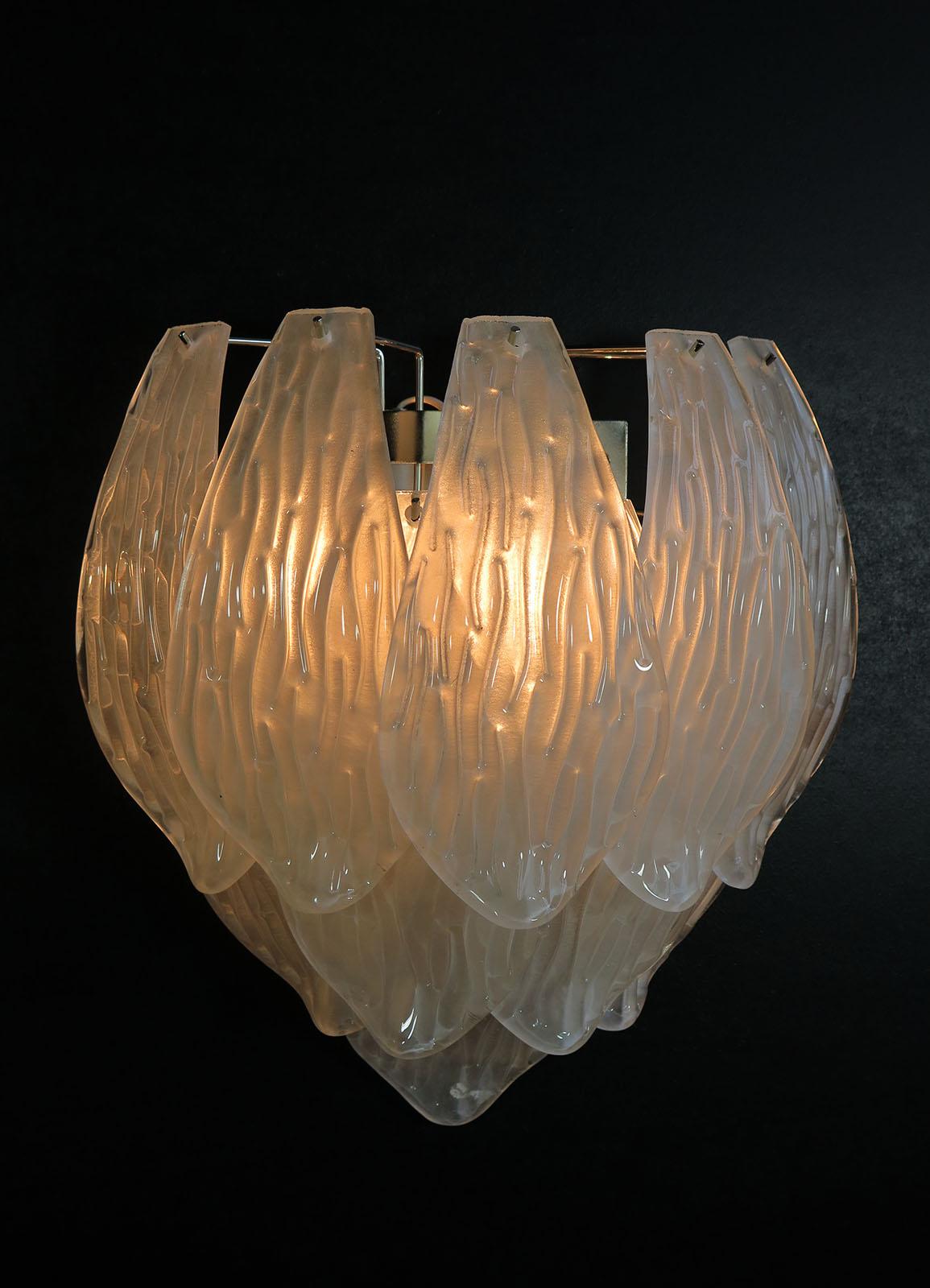Fantastic pair of vintage Murano wall sconce made by 10 handblown transparent frosted carved glass leaves for each applique in a chrome metal frame.
Period: late XX century
Dimensions: 15,75 inches height (40 cm); 14,20 inches width (36 cm); 7,90 