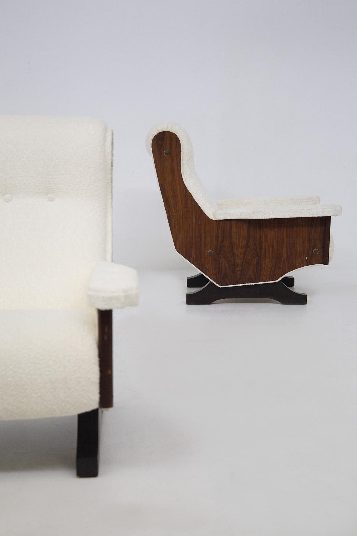 Cette paire de fauteuils vintage a été fabriquée dans les années 60. Elles sont en bois de noyer et fabriquées par des fabricants italiens de qualité. Les chaises élégantes ont été retapissées en boucle blanche. La forme particulière consiste en un