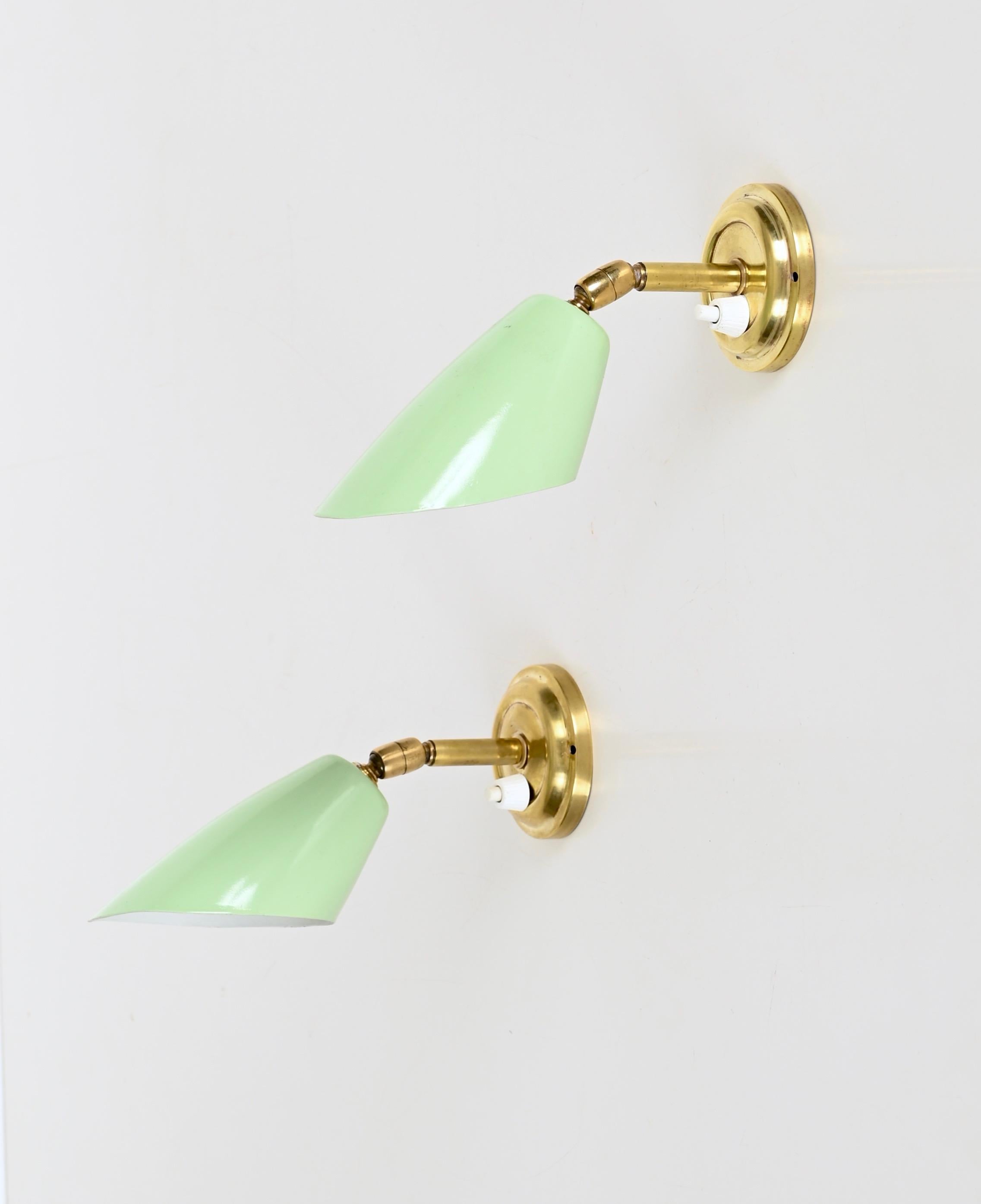 Marvelous and rare pair of sconces in brass and pistachio green enameled metal. Completely original and in amazing conditions, this incredibly beautiful wall lights were designed by Giuseppe Ostuni and produced in Italy during the 1950s. 

These