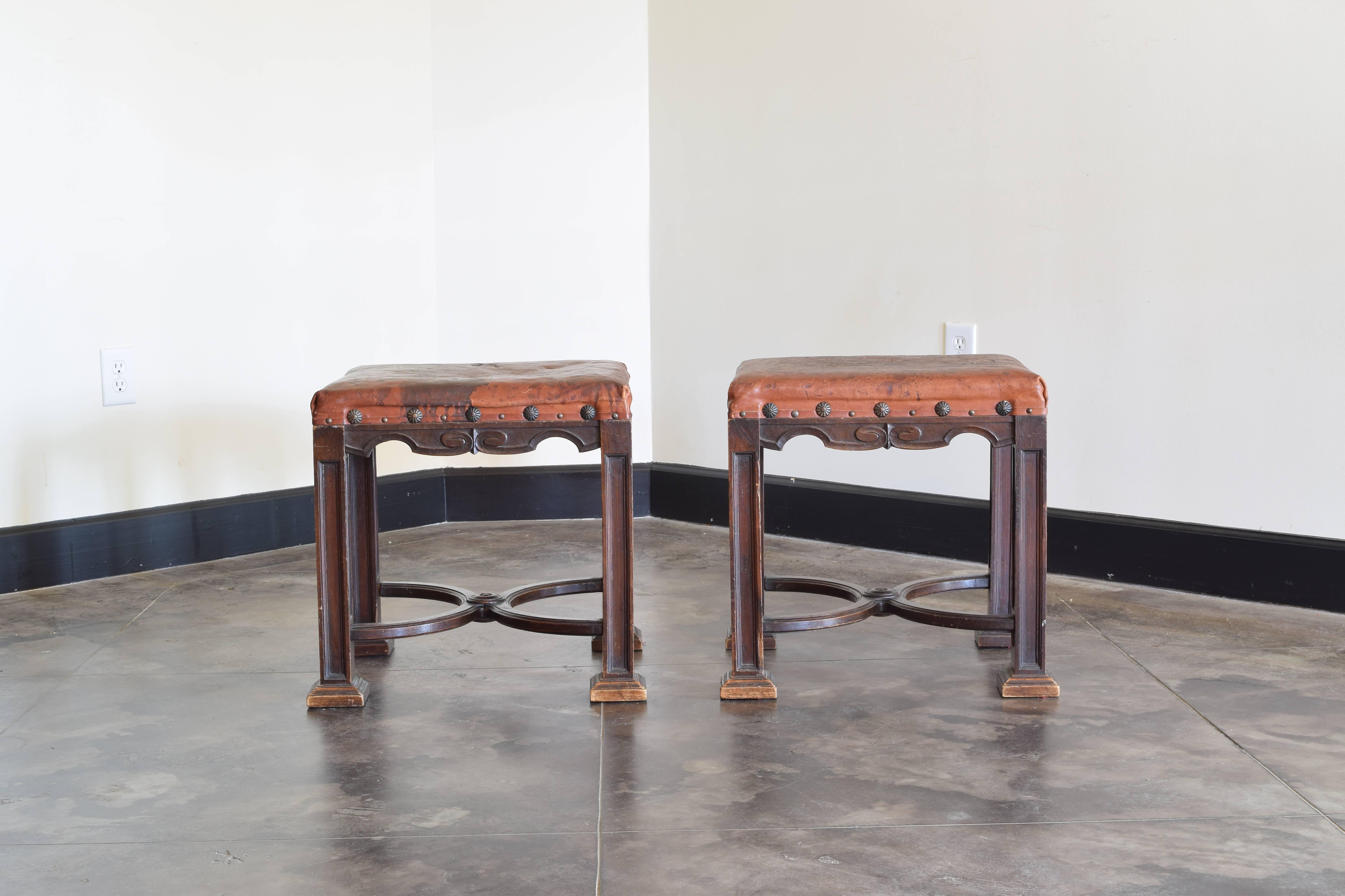 the rectangular seats upholstered in leather and trimmed in patinated brass nailheads, raised on square legs with channeled edges and resting on plinth-form feet, joined by shaped x-form stretchers
19th Century