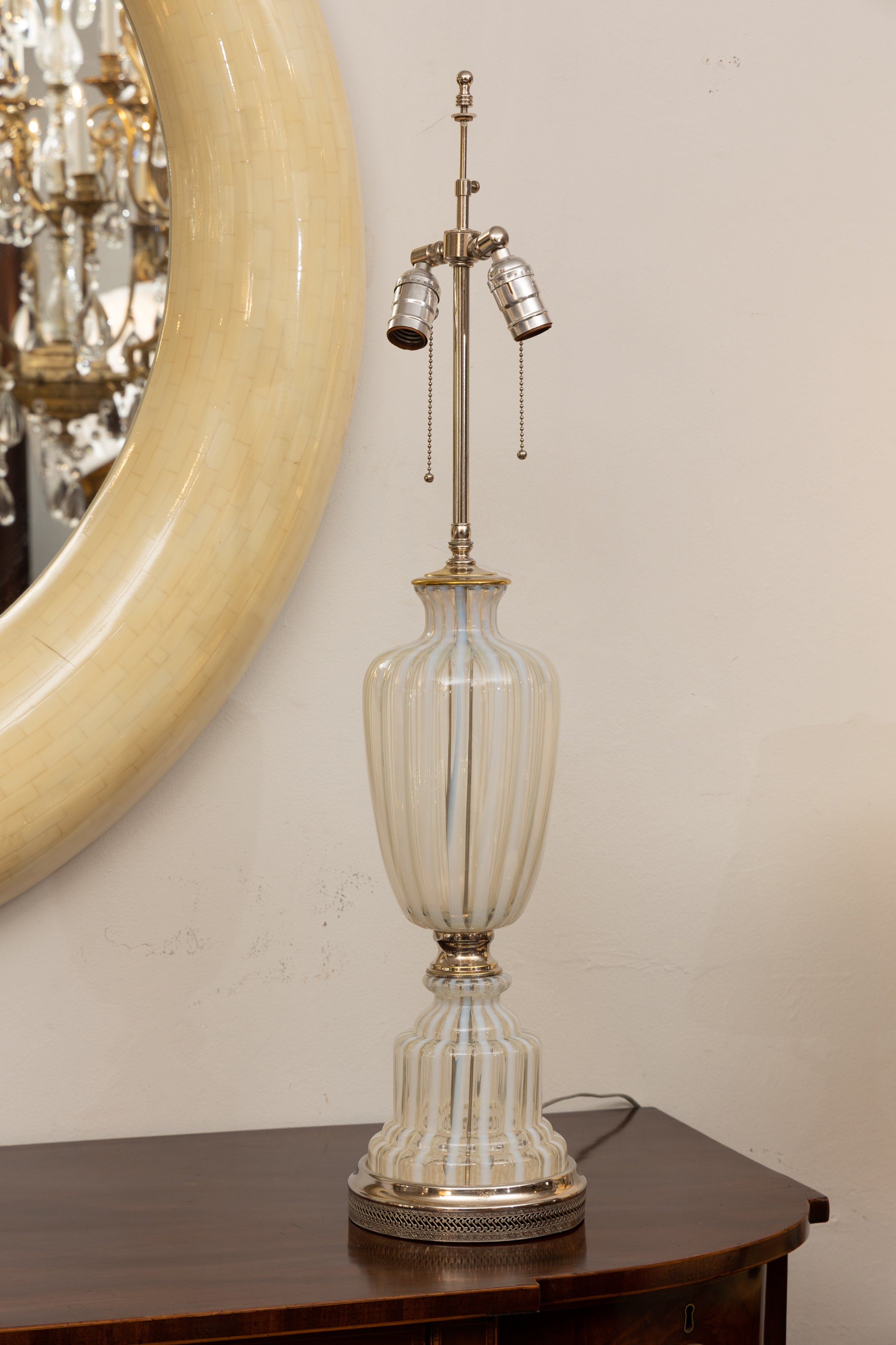 This is a lovely pair of Italian Murano urn-form glass lamps comprised of repetitive alternating stripes of white and clear glass, early 20th century.