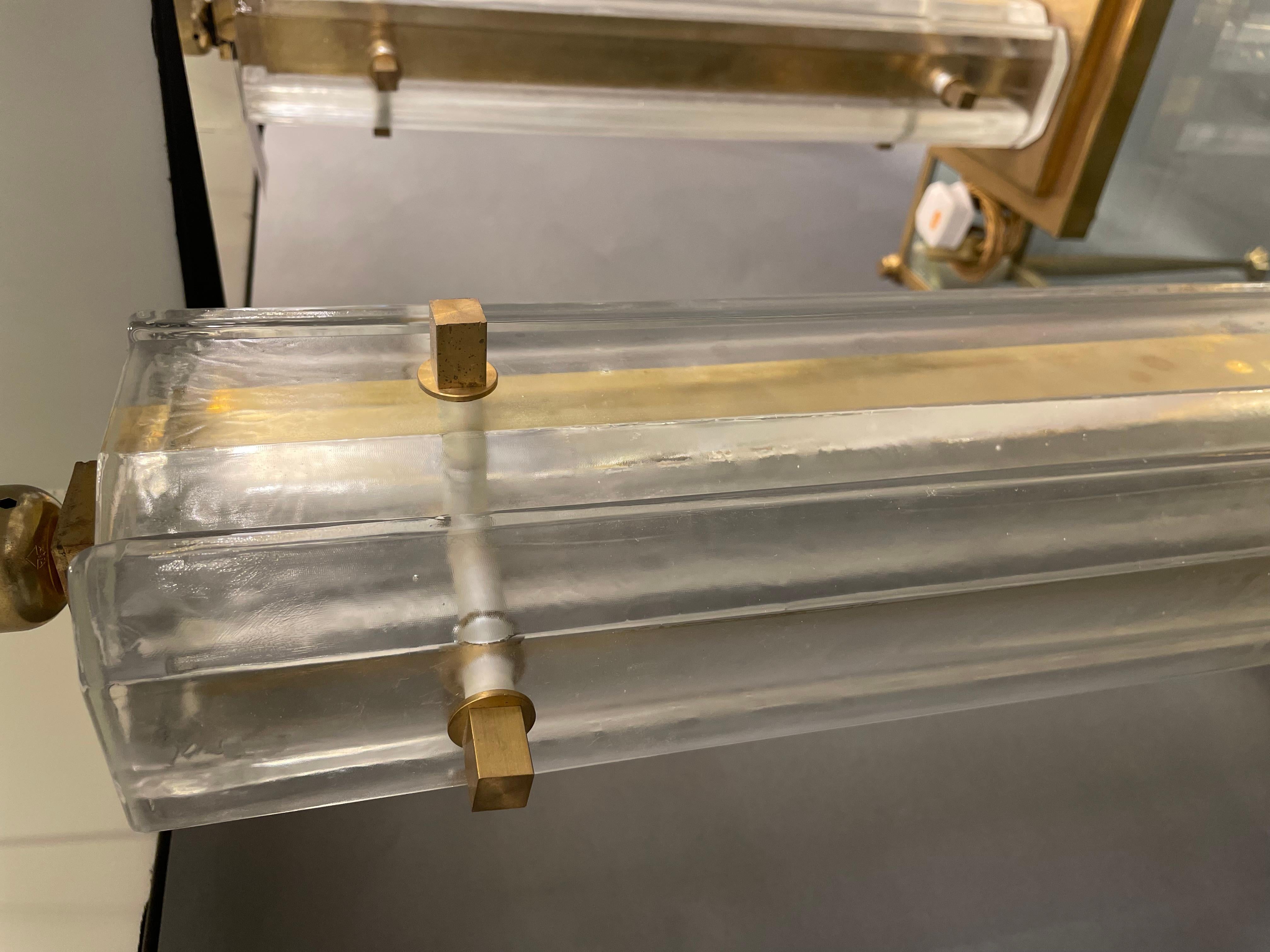 Ein bedeutendes Paar Lampen aus Muranoglas, jede mit vier Platten aus weißem Milchglas, die symmetrisch um eine Messingplatte angeordnet sind, die in den zentralen Schaft hineinragt. Der Sockel ist quadratisch und ebenfalls aus Messing. Dies ist ein