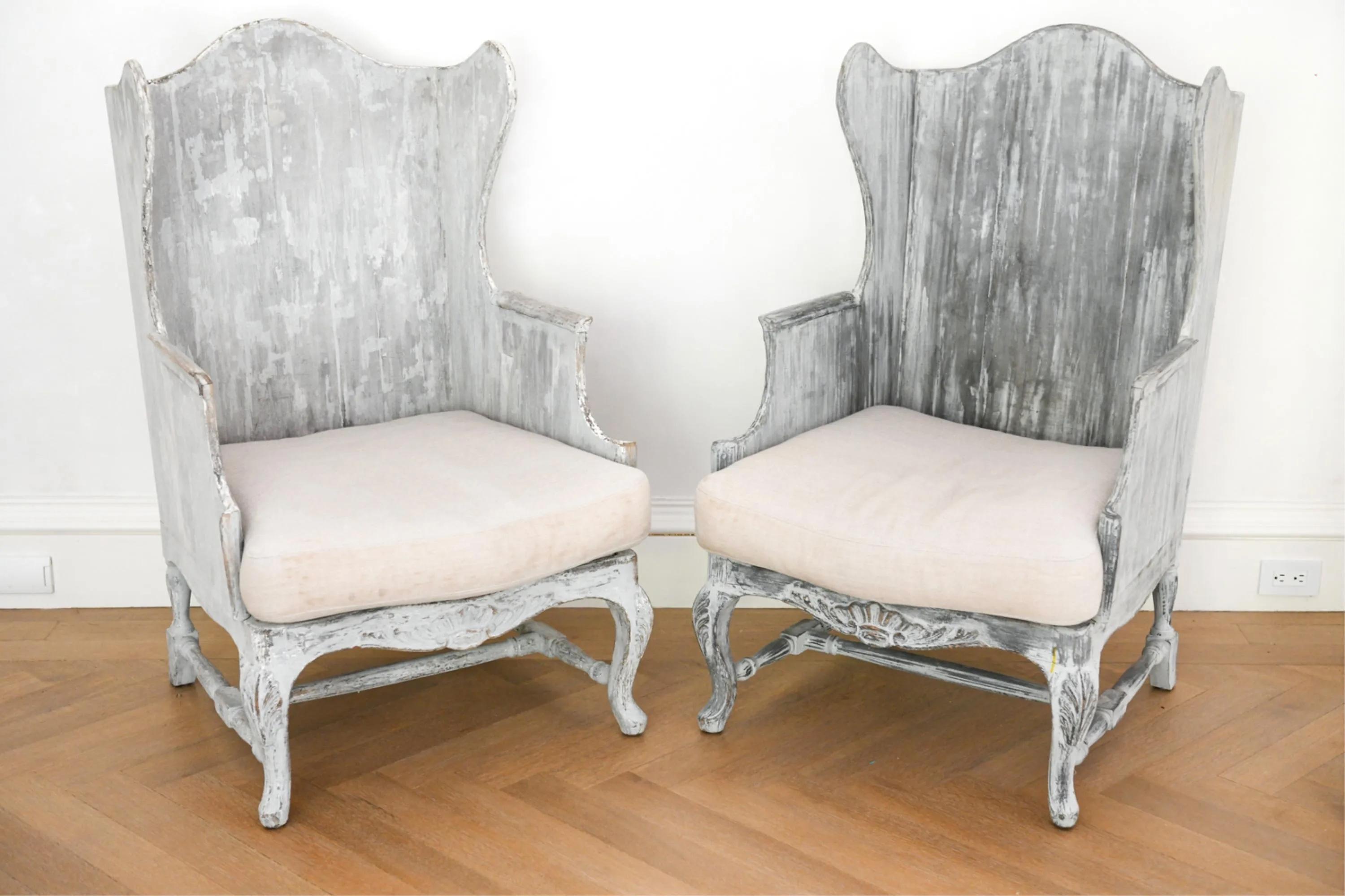 Pair of Impressive, highly stylish and unique Italian painted wood frame wing back arm chairs that will bring presence to any room. Chairs have a full wood frame and a loose cushion. The painted wood frame. is intentionally distressed. The cushions