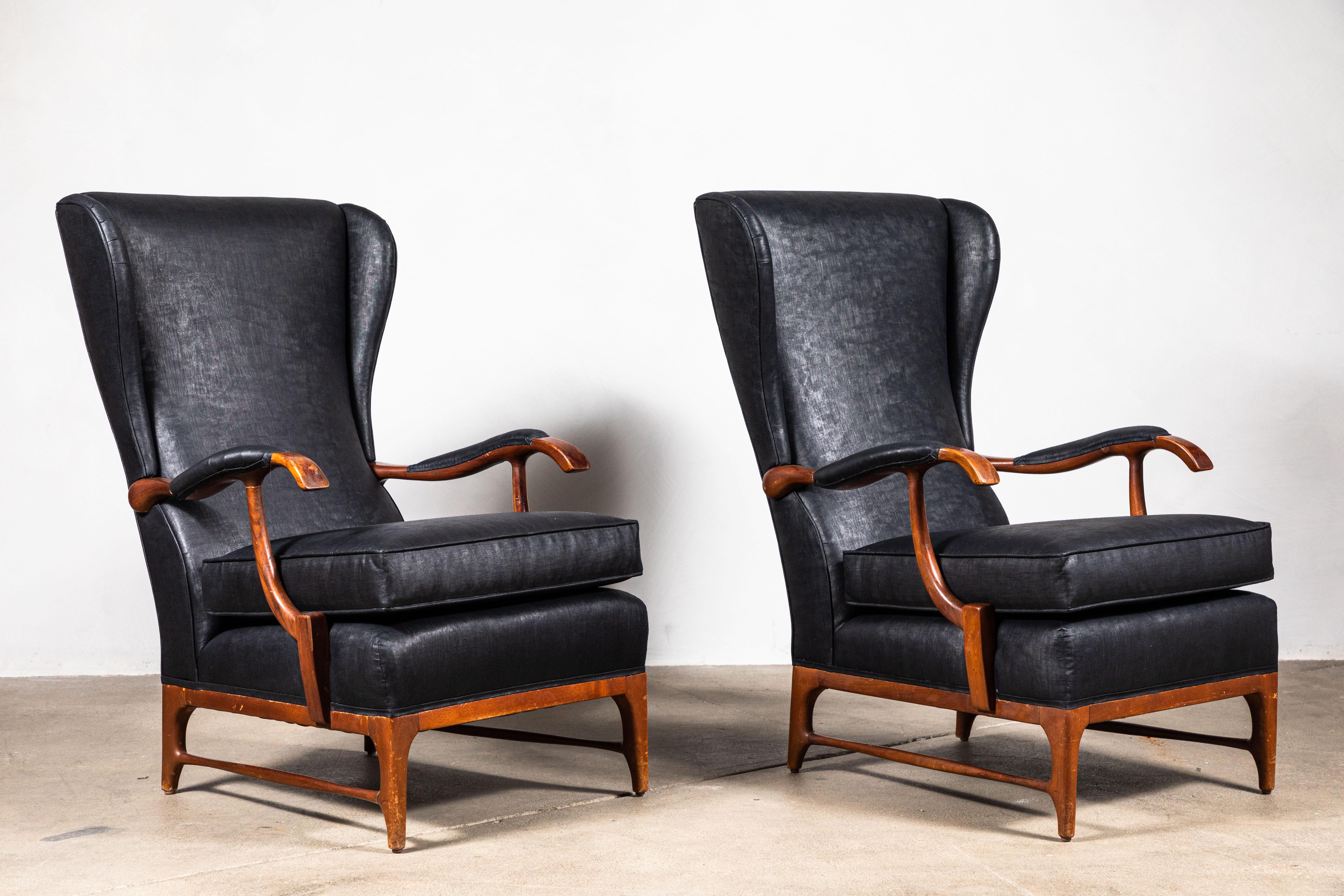 Elegant pair of Italian slender black wingback chairs newly upholstered in black beetled linen from London based Fabric House, 36 Bourne Street. Chairs are framed in original walnut wood.