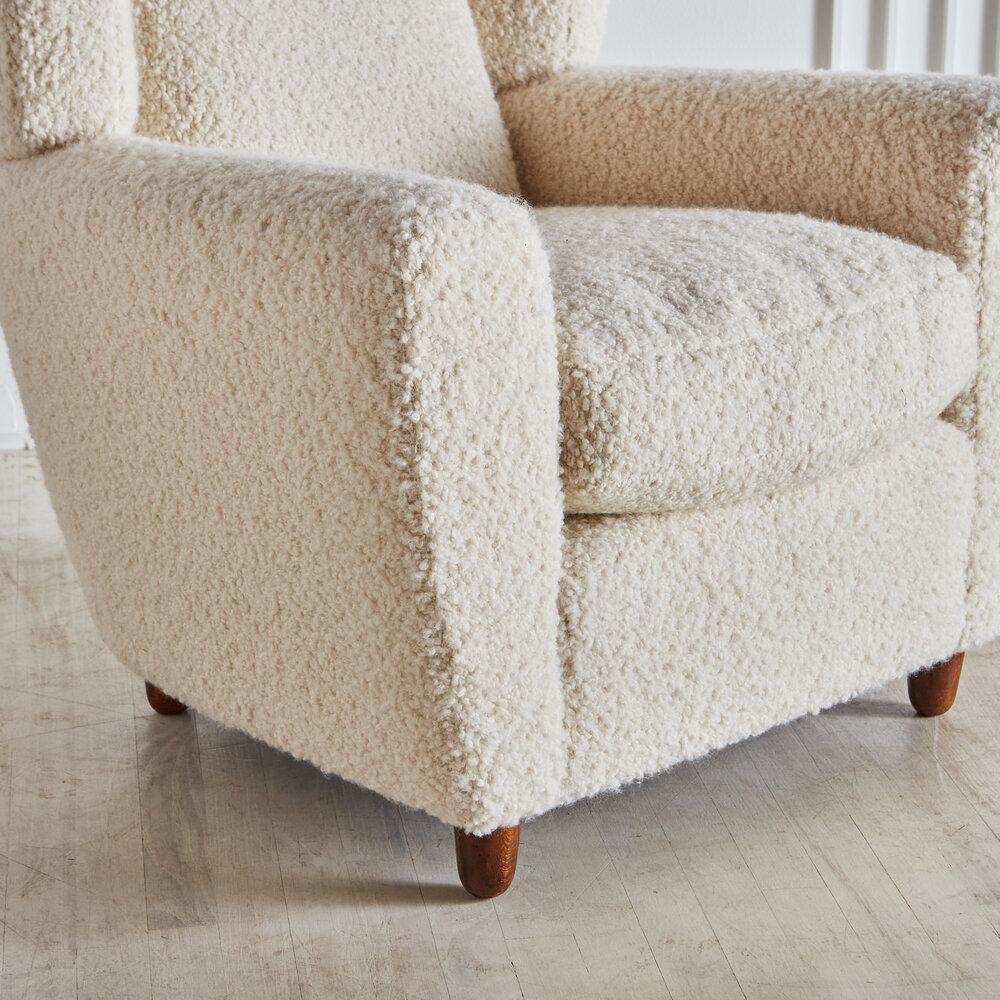 A stunning pair of Italian Wingback lounge chairs newly upholstered in an Alpaca wool blend by Great Plains with 100% down cushions. Featuring stately arms and a dramatic wingback with tapered wooden feet. This extra plush fabric offers a modern