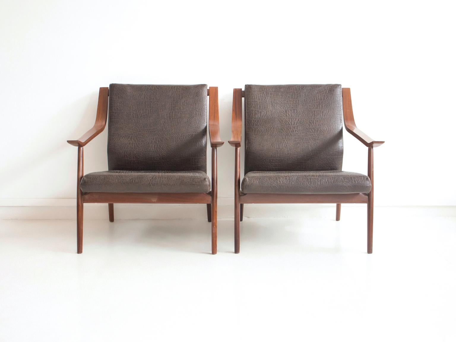Pair of 1950s armchairs with wooden structure. Seat and back cushions covered in dark brown embossed imitation leather. Manufactured in Italy.