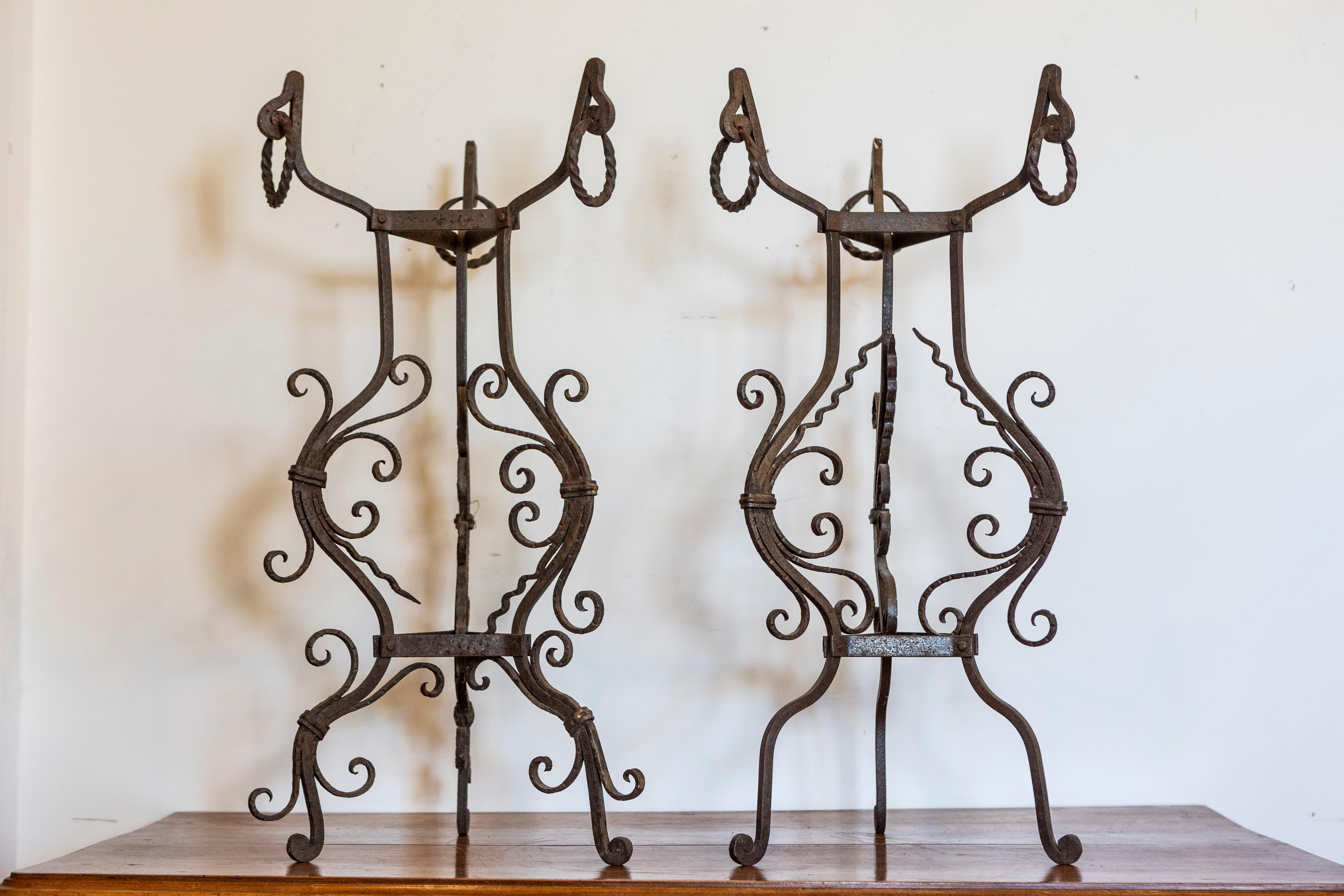Coppia di piantine italiane in ferro battuto realizzate a mano su basi a treppiede, risalenti al 1900 circa, con accenti di scorrimento. Questa splendida coppia di piantane italiane in ferro battuto del 1900 circa mette in mostra la maestria e