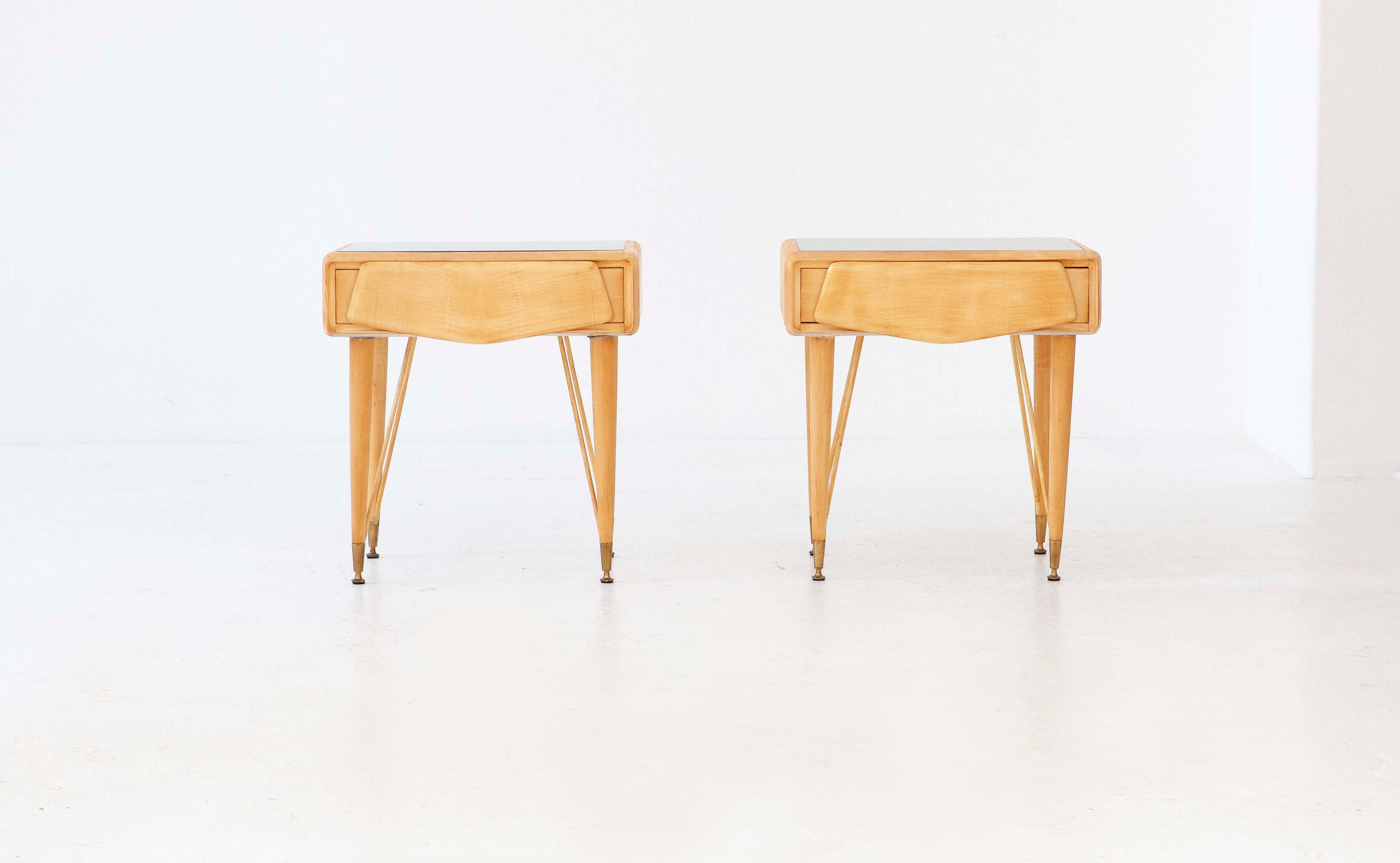 Set of two nightstands, manufactured in Italy during the 1950s 

These two side tables has a long solid wood legs that support a small light wood cabinet with a drawer , on the top is placed a back-lacquered glass in grey

Airy and modern