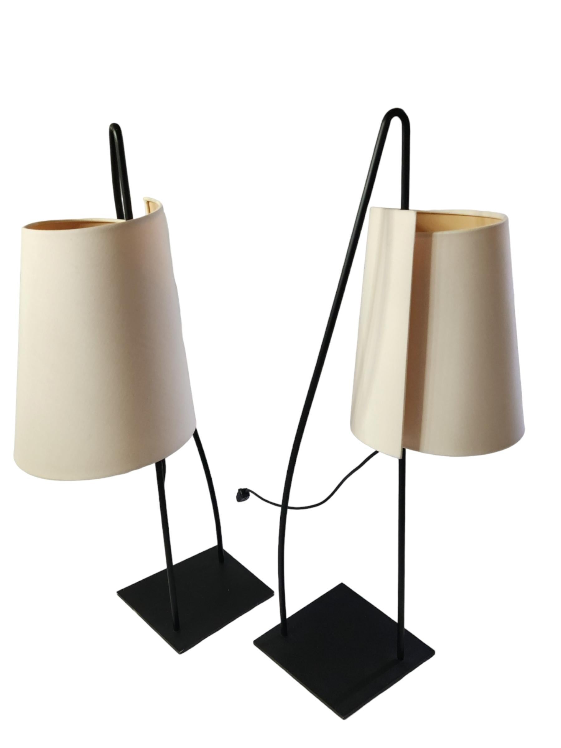 A pair of Italian sculptural table lamps by Italiana Luce manufactured in Italy, circa 1980s.
The black lacquered base plates are slightly trapezoid. and support a curved black lacquered metal loop.
The cast plastic sockets slides up and down and
