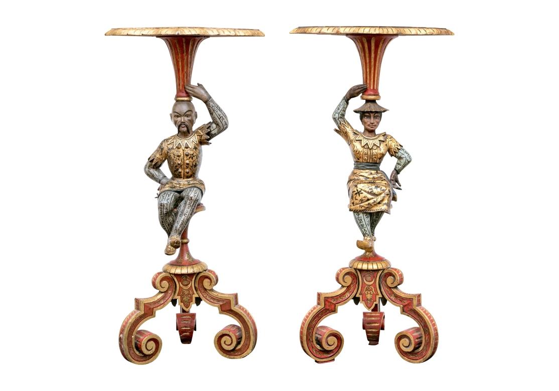 Extraordinaria Pareja de Figuras de pie de estilo Chinoiserie italianizante compuestas de gesso y madera tallada en forma de hombre y mujer sentados que portan una bandeja en forma de rombo. Las figuras están coronadas por una base trípode con