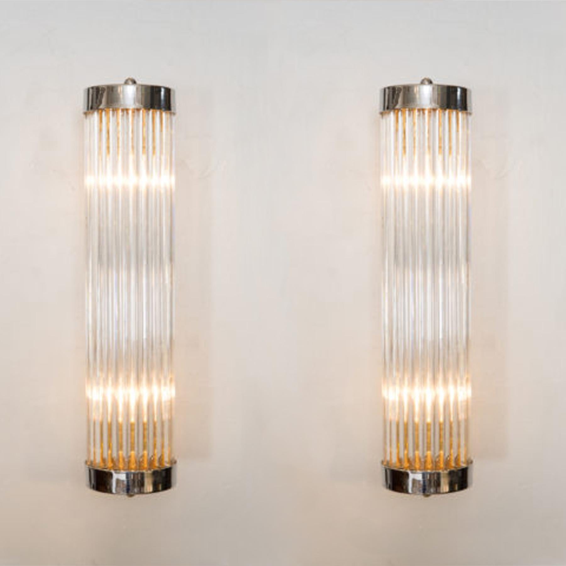 Contemporary Art Deco inspired Italian wall lights in the style of ‘Venini’.
Each light comprises of a circle of slim Murano glass rods capped top and bottom by round brass plates that attach with two slim brass arms to a brass wall bracket.
Two