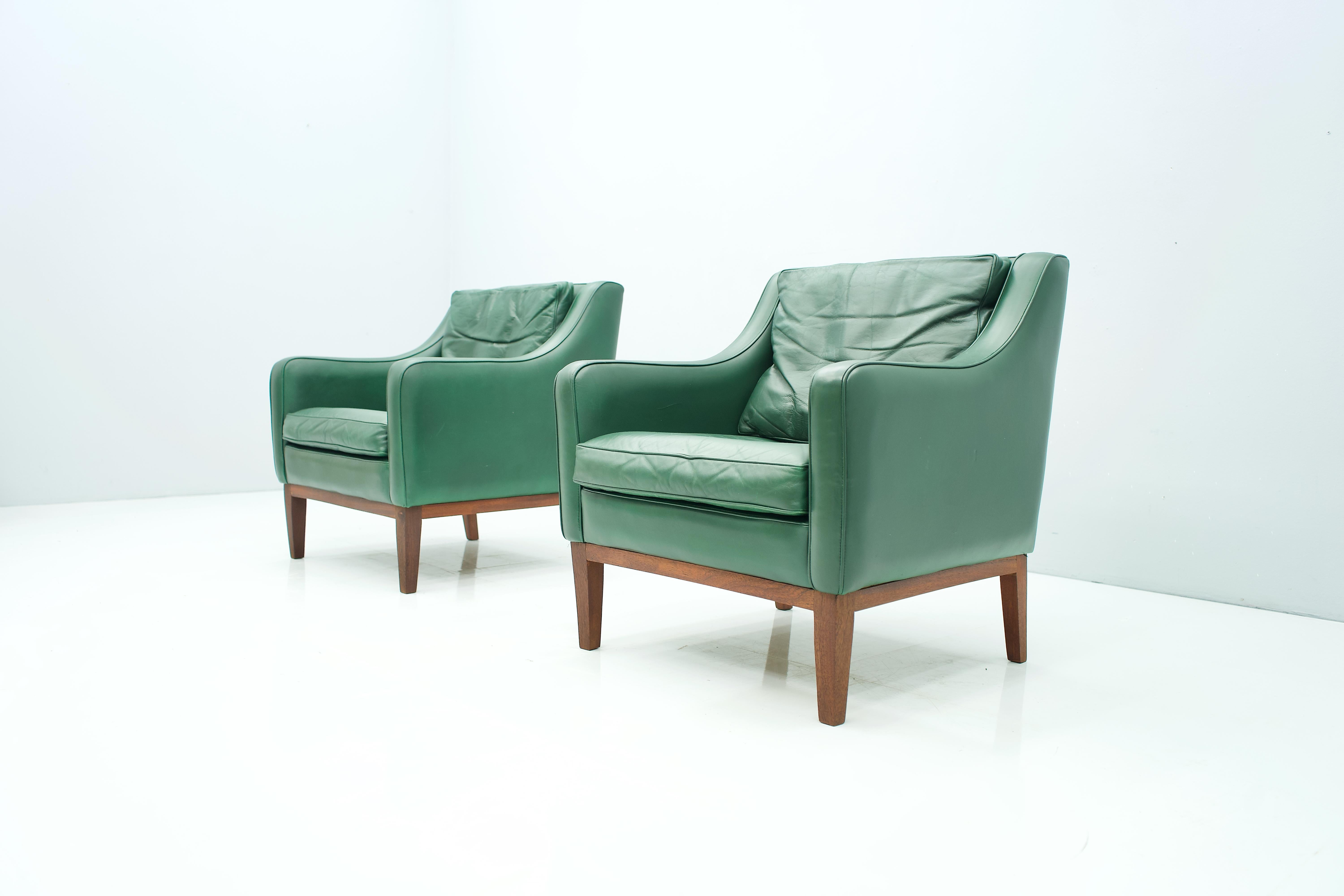 Pair of beautiful lounge chairs in green leather and wood frame (teak). The pillows are partly filled with down. The set was bought together with the matching 2-seat sofa in 1958. Origin Italy.
Measures: H 76.5 cm, W 70 cm, D 71 cm, SH 40 cm.
Good