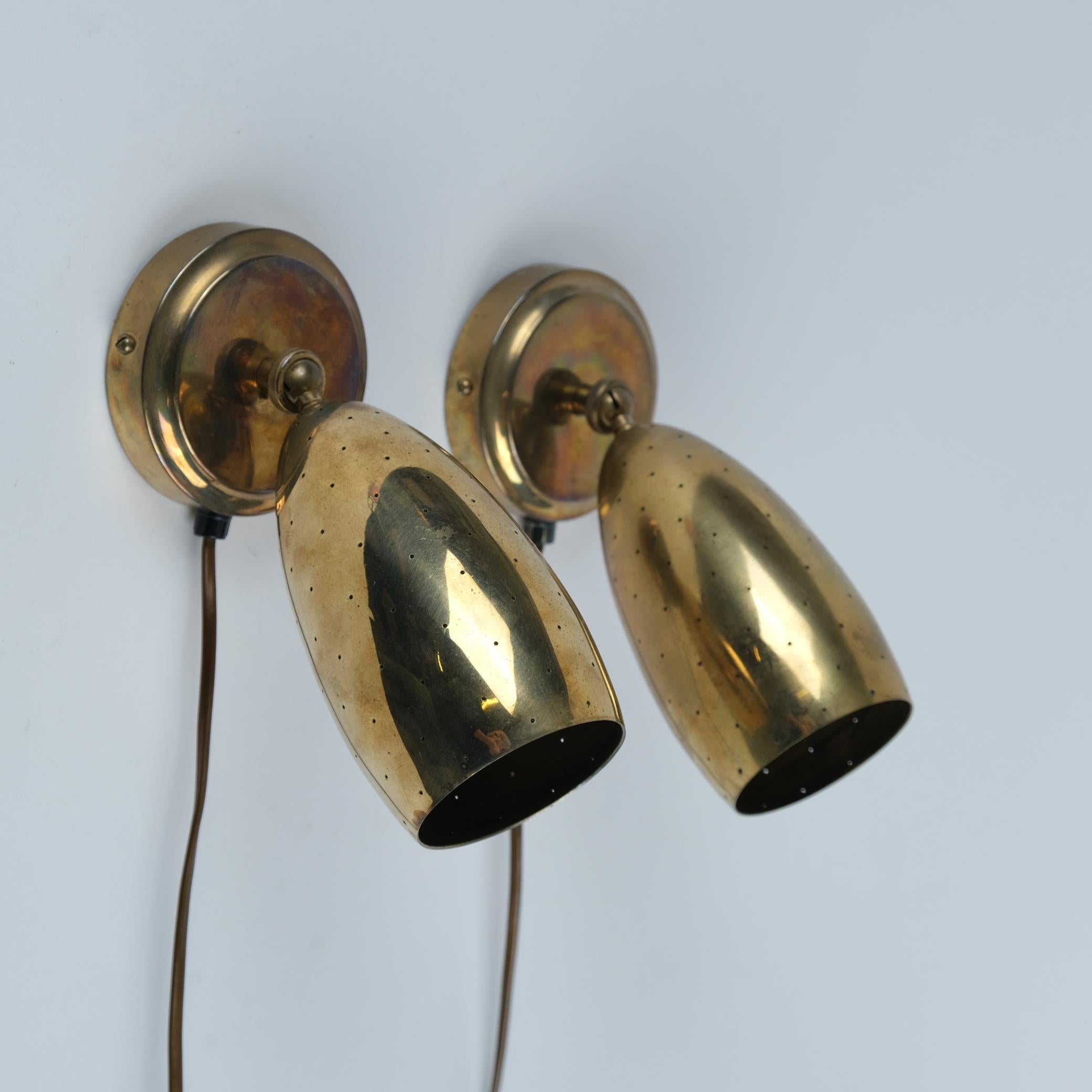 A pair of small adjustable wall lamps model EY 67, manufactured by Itsu in Finland in the 1950s. Although smalle in size, this wall lamp has an elegant appearance, and stands out effortlessly in any interior with its perforated shades that also