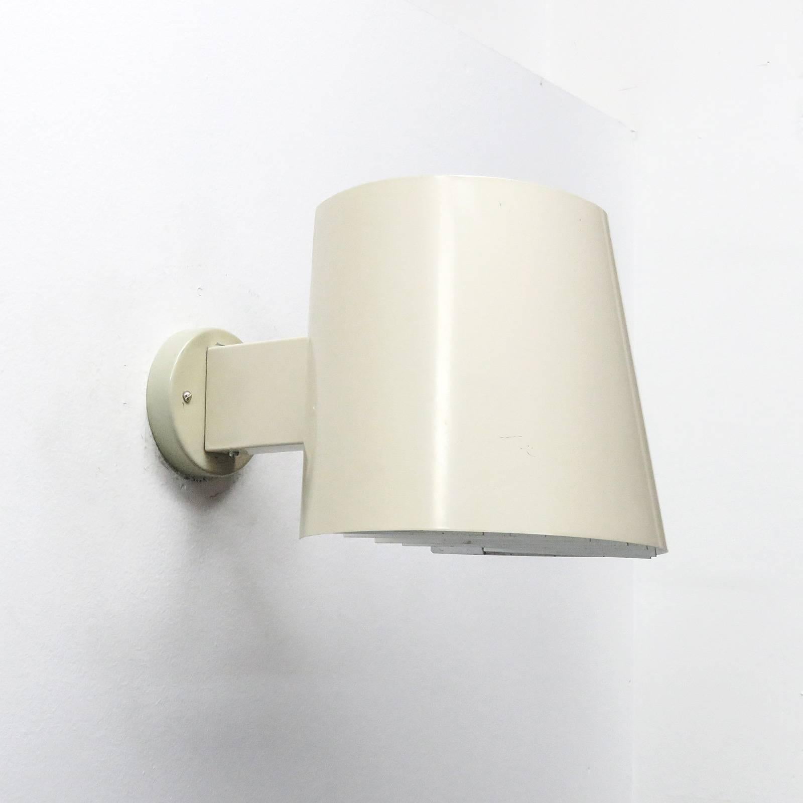 Wonderful 1960s pair of off-white enameled metal up-/down wall lights by Itsu, model AH 48, white reflector grille to the bottom, marked, one E27 socket per fixture, max. wattage 100w each, bulbs provided as a one time courtesy.