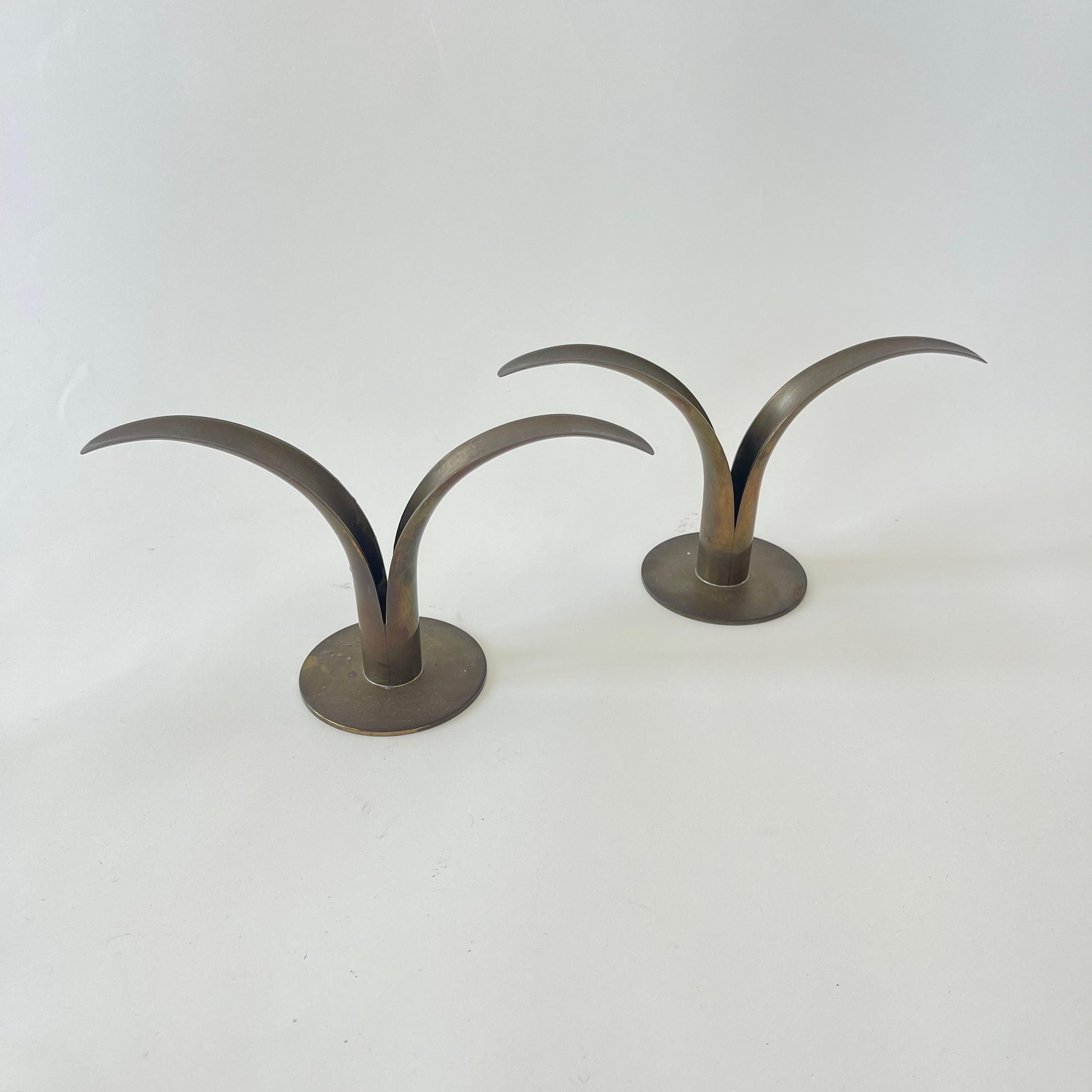 Pair of iconic Lily candlestick candle holders, rendered in patinated brass with a sculptural lily flower motif.  Designed by Ivar Ålenius Björk for Ystad-Metall, Sweden, Circa 1940s. marked on bottom