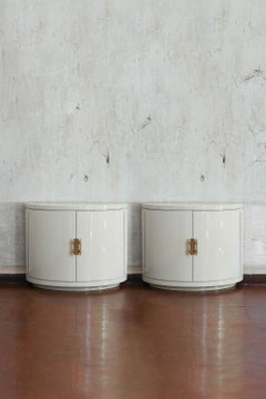 Pair of ivory lacquered half-moon sideboards with brass details, 1930s.