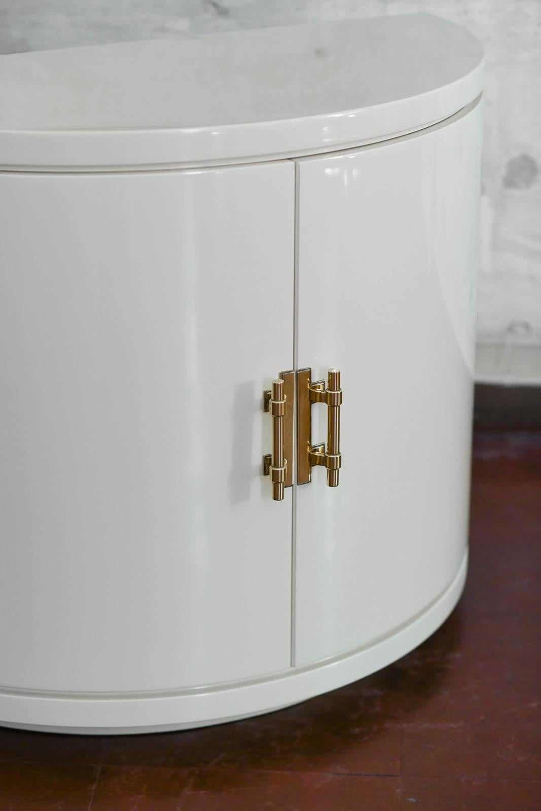 Brass Pair of ivory lacquered half-moon sideboards with brass details, 1930s. For Sale