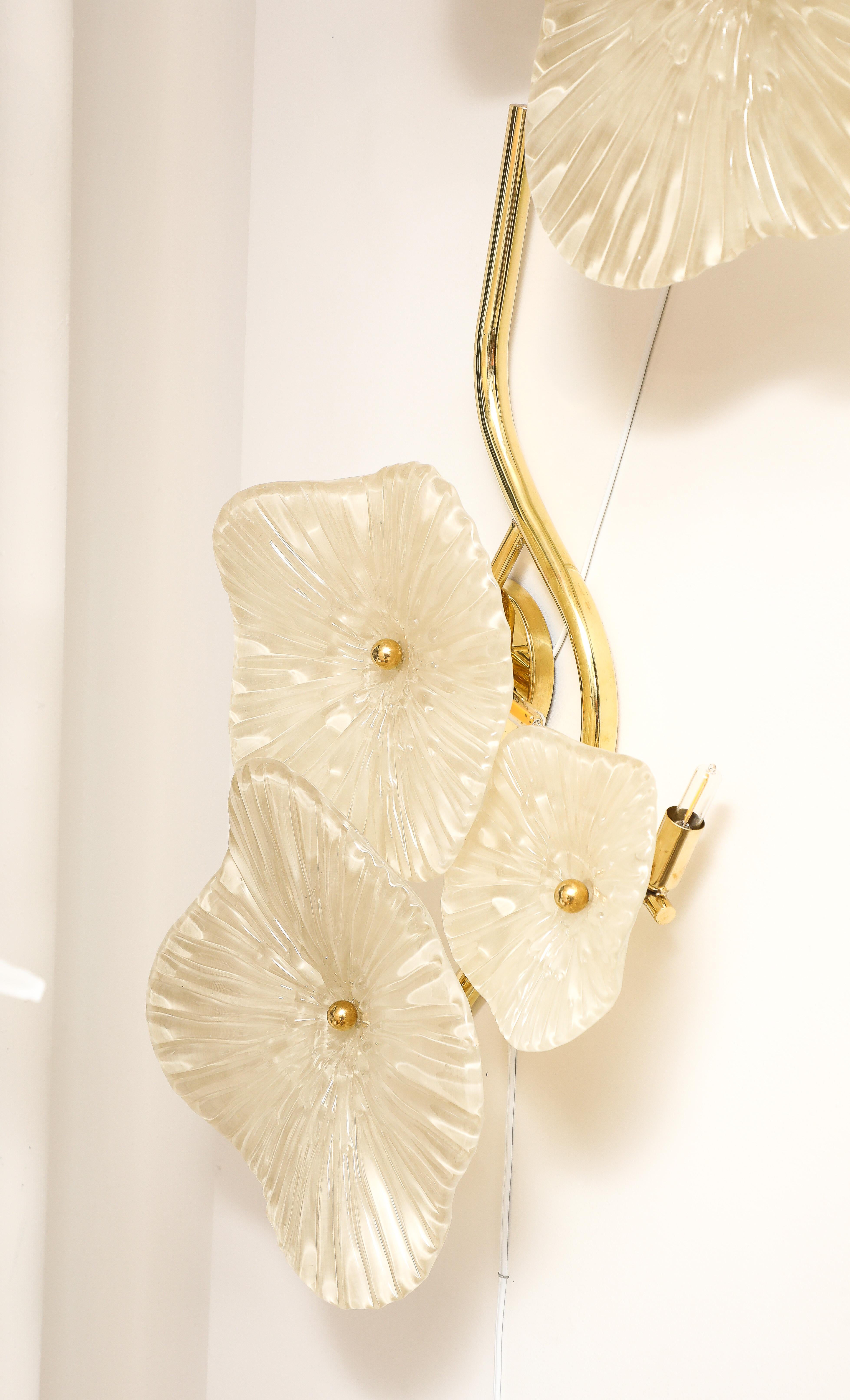 Paar von weichen Elfenbein Murano Glas Blume Wandleuchte oder Wandkunst mit Messingrahmen. Handgegossene und geformte Blumen aus Murano-Glas in zartem Elfenbein sind mit einer Messingkappe an Messingstielen befestigt. Die Murano-Glasblumen variieren