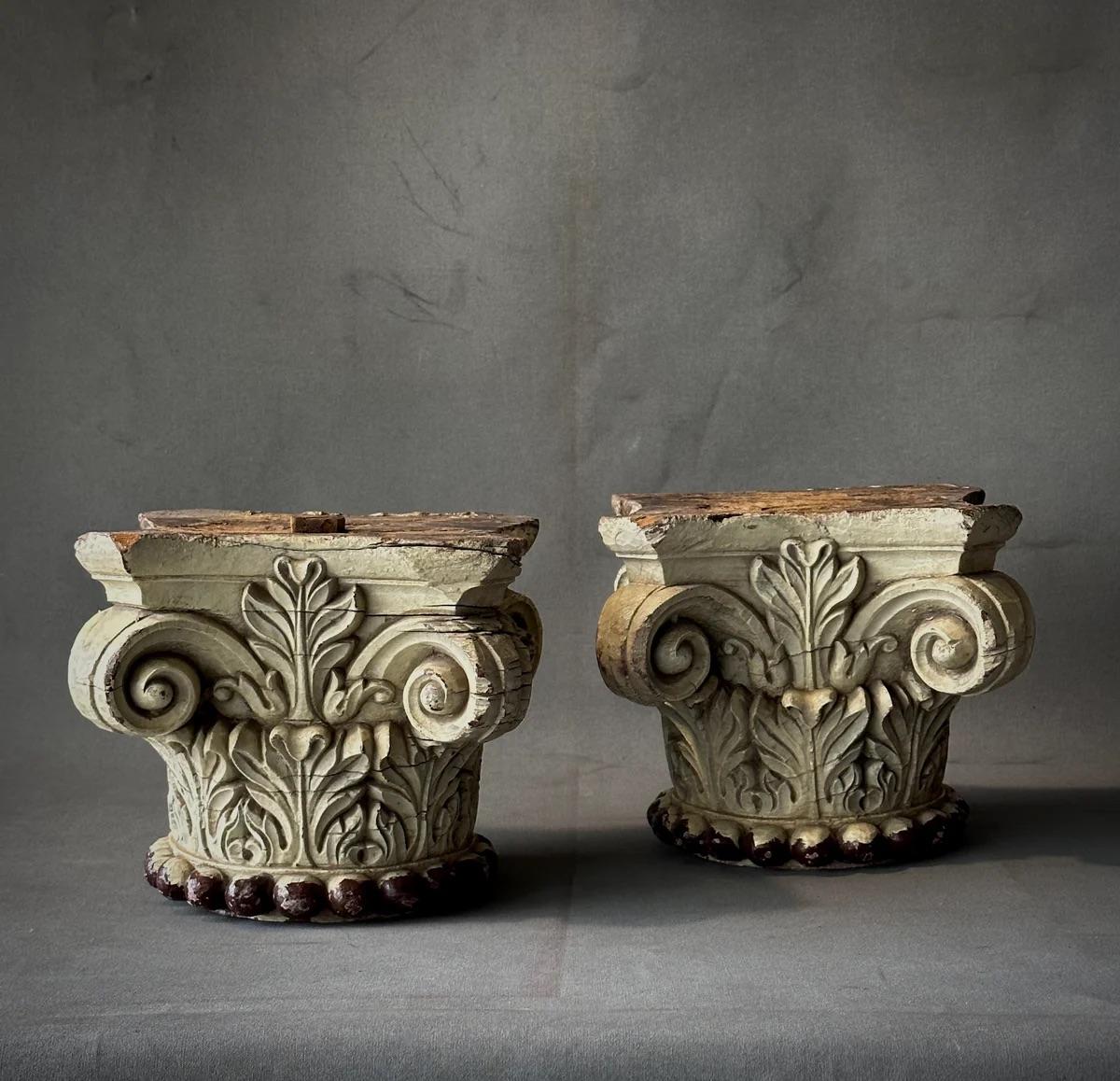 Cette paire de chapiteaux en bois italiens anciens dégage une beauté classique. Ils étaient à l'origine destinés à orner le sommet de colonnes composites. Leur peinture ivoire s'est transformée en une patine finement vieillie, soulignée par des