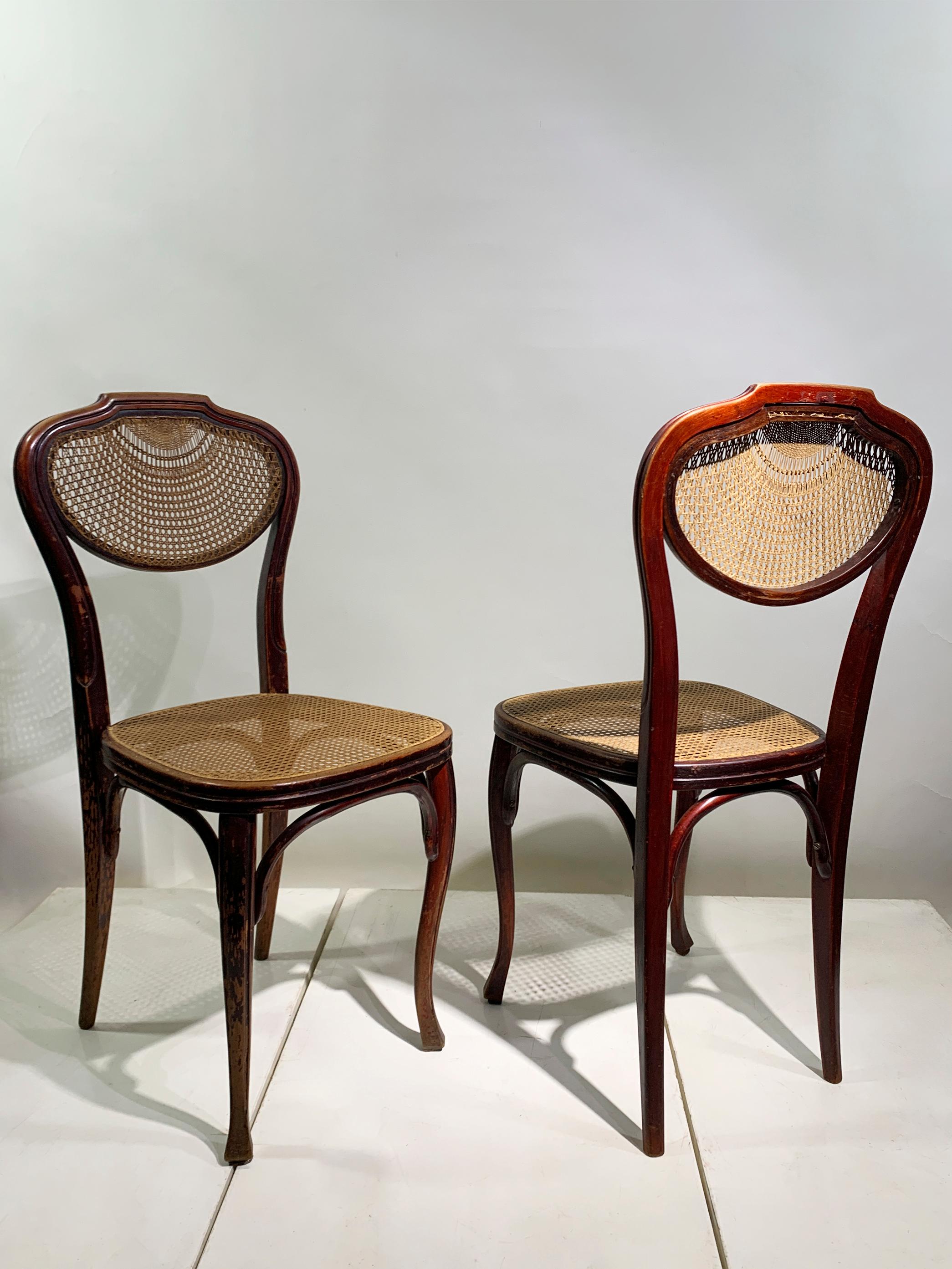 Cette élégante paire de chaises anciennes en bois courbé, fabriquée par la célèbre entreprise autrichienne J. & J. Kohn, illustre la beauté intemporelle et la maîtrise technique du design du début du siècle. La marque 