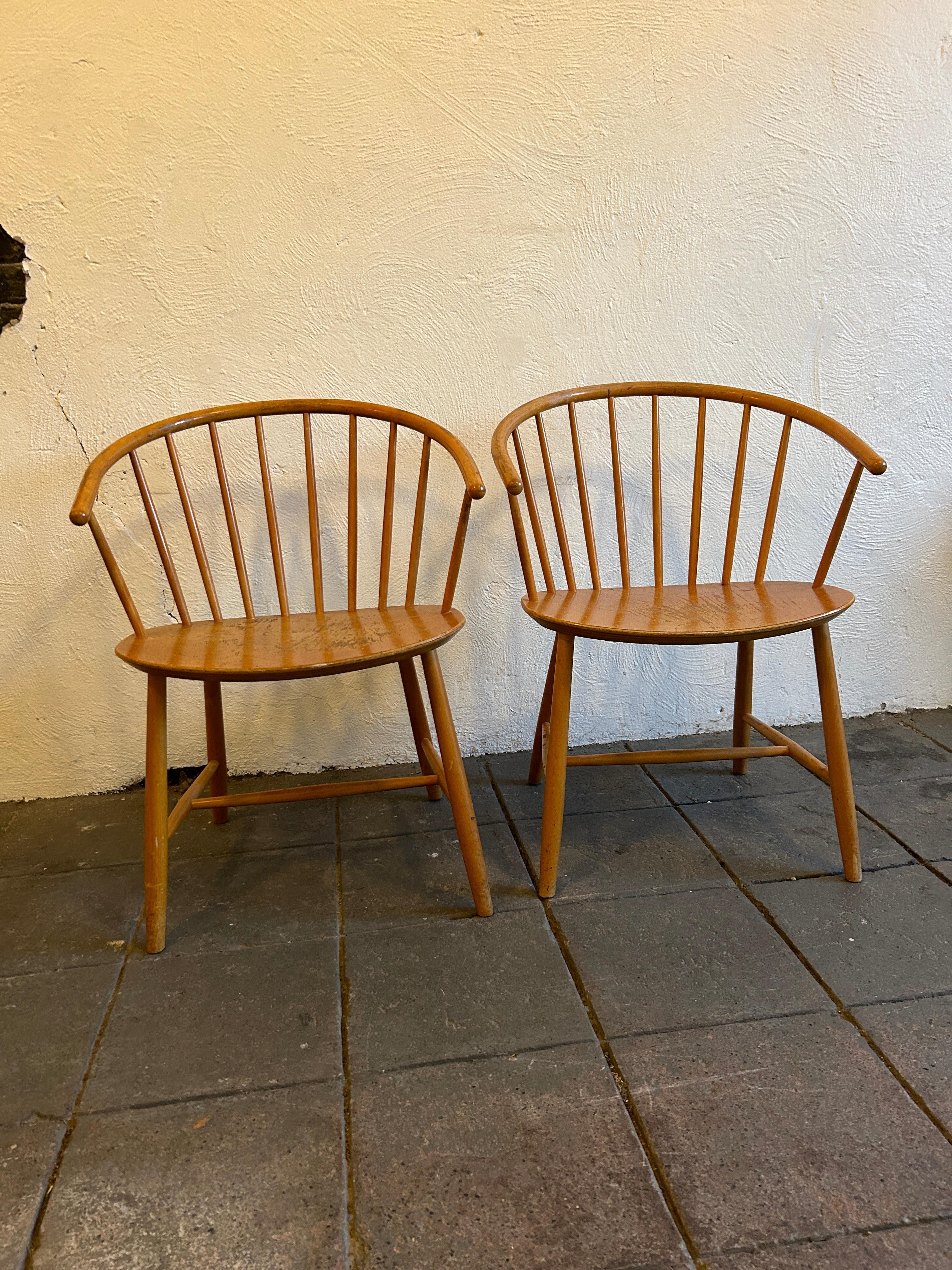 
Pair of vintage Ejvind A. Johansson J64 Side chairs for FDB Mobler. Mid 20th century. Windsor-style armchairs with bentwood arms, splats, and legs. FDB logo stamps, brand marks, and Made in Denmark impressed into undersides of both chairs. Wear and