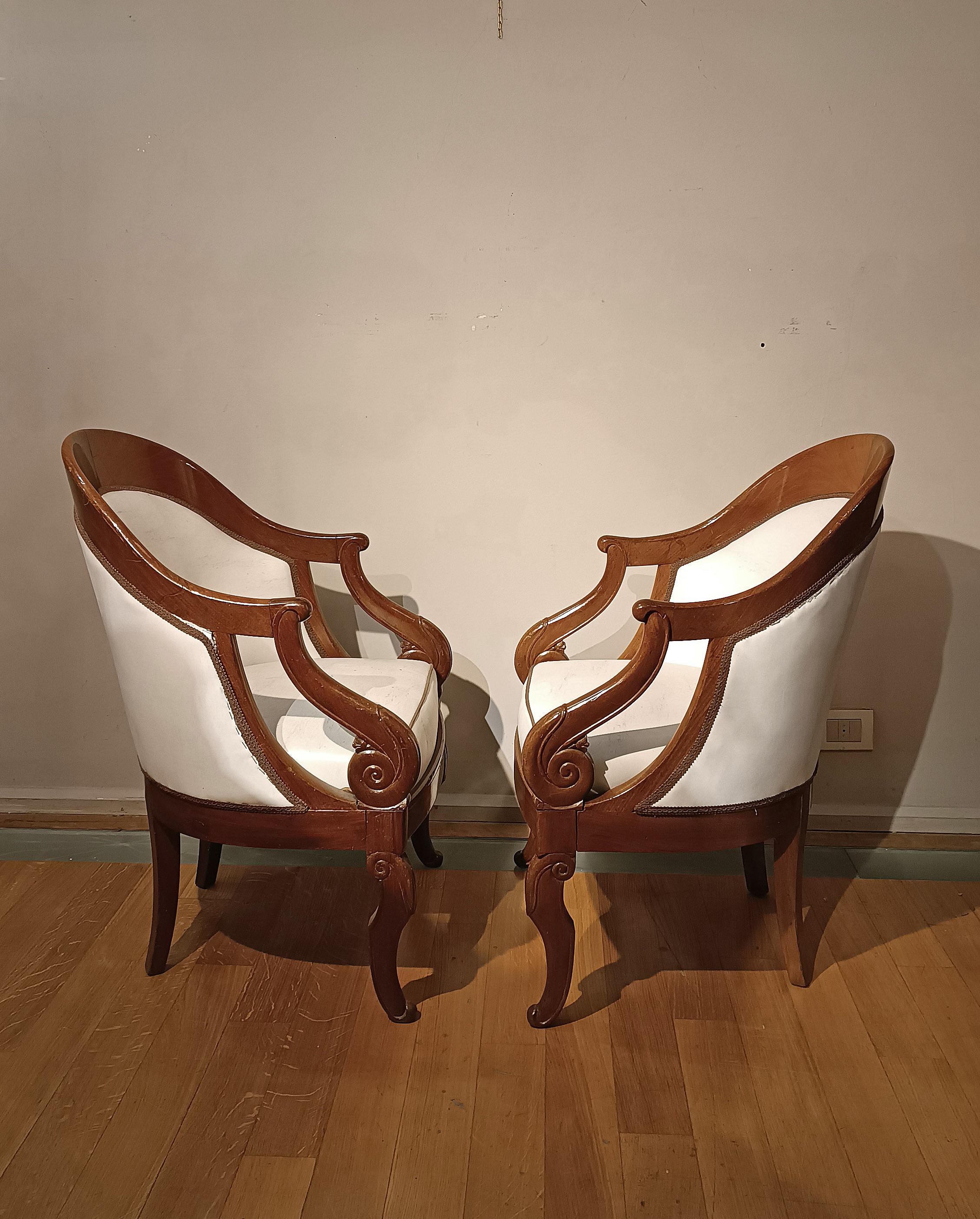 Importante paire de fauteuils baignoires Jacob, en noyer massif et équipés d'un rembourrage en éco-cuir blanc. Ces fauteuils se caractérisent par leurs accoudoirs bouclés et leurs pieds en corne d'abondance stylisés, éléments qui apportent une