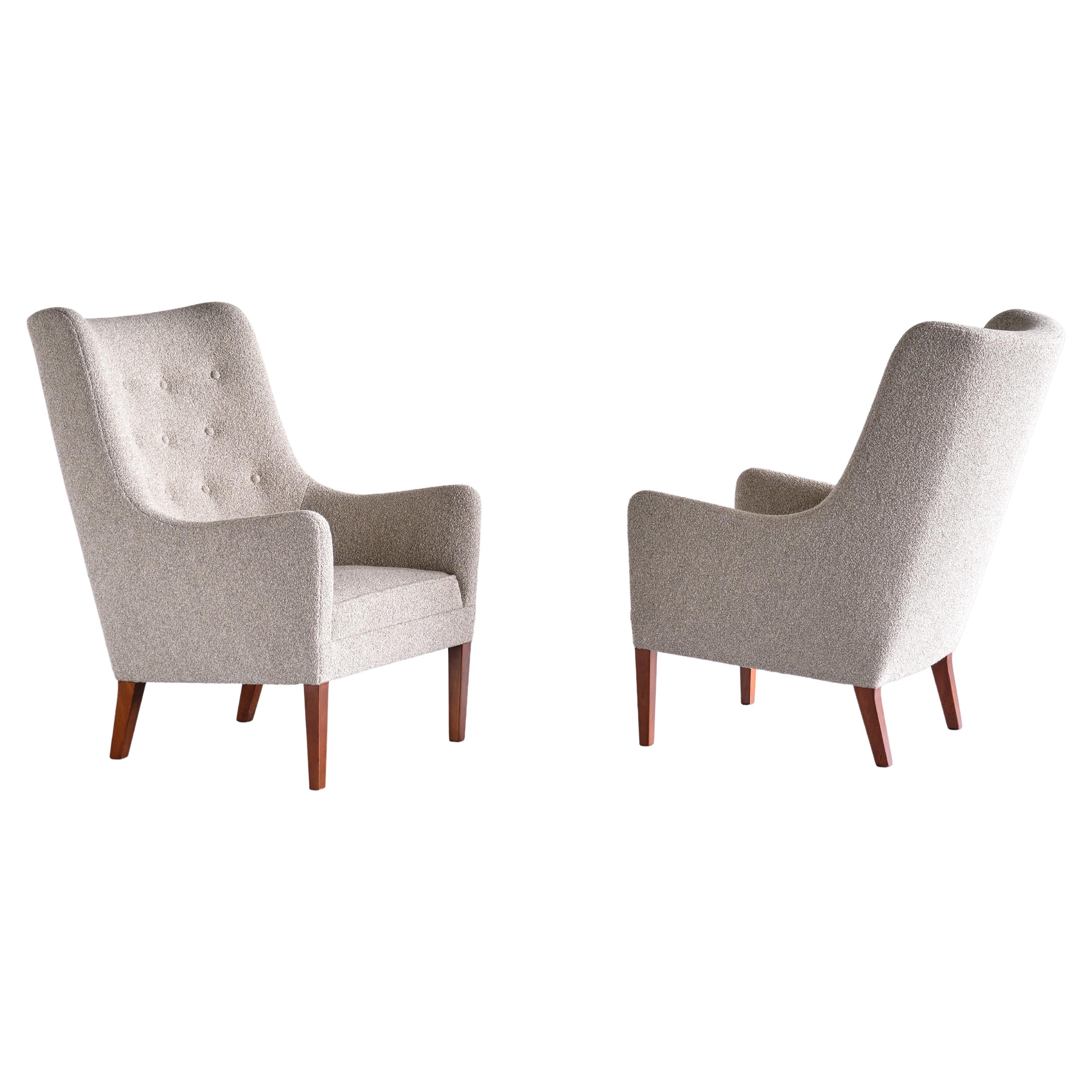 This very rare pair of armchairs was designed and produced by Jacob Kjær in Denmark in the late 1940s. The sumptuous design is marked by the distinct combination of curved and straight lines of the seat. The high back with the buttoned backrest and