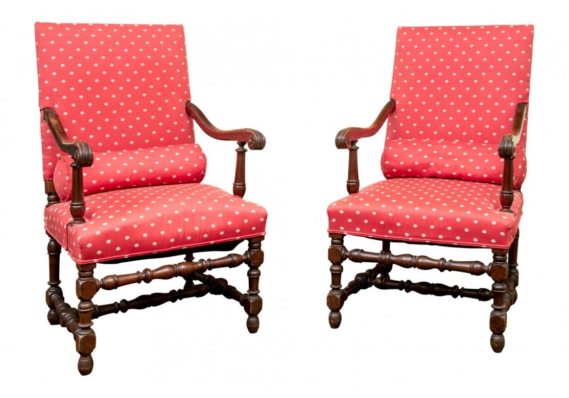 The pair finely carved with acanthus leaves on the tops and ends of the scrolled arms with turned supports. The lower frames with elaborately turned legs, front stretchers and H stretchers. Nicely upholstered in a red fabric with white shells. Along